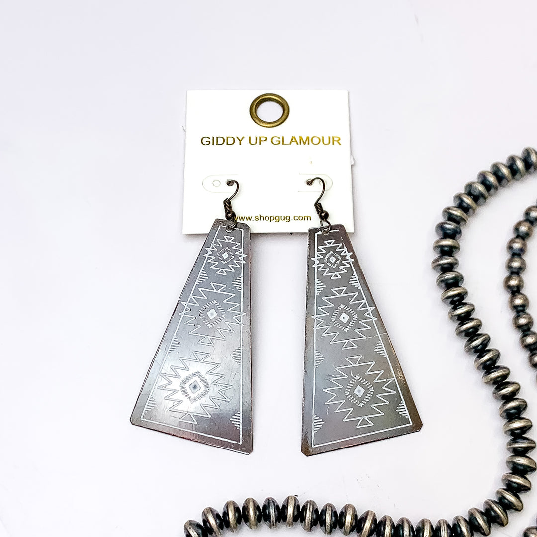 Aztec Tooled Earrings in white and Copper Tone. Pictured on a white background with beads to the right of the earrings for decoration.