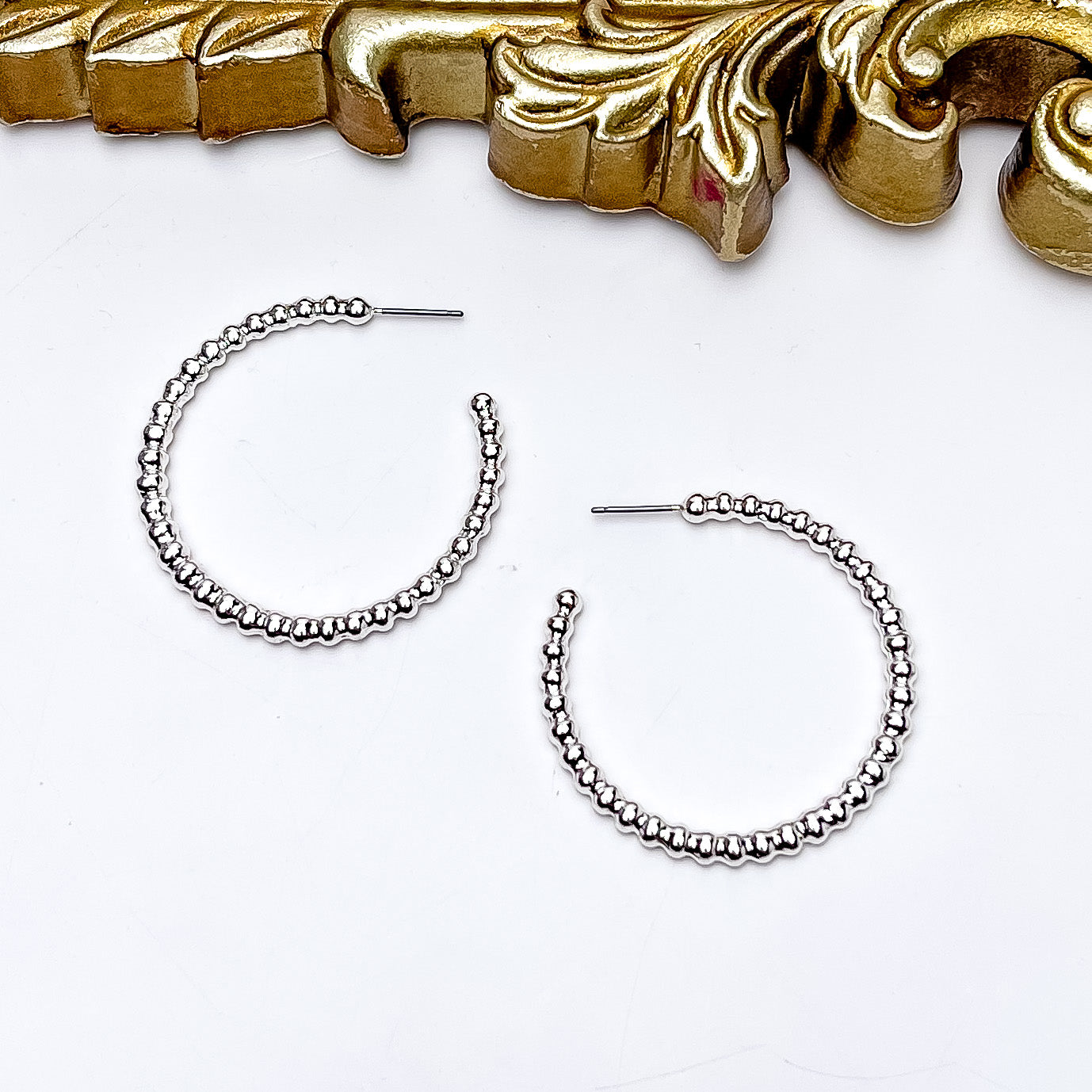 Silver Tone Connecting Beads Hoop Earrings. Pictured on a white background with a gold frame above the earrings.
