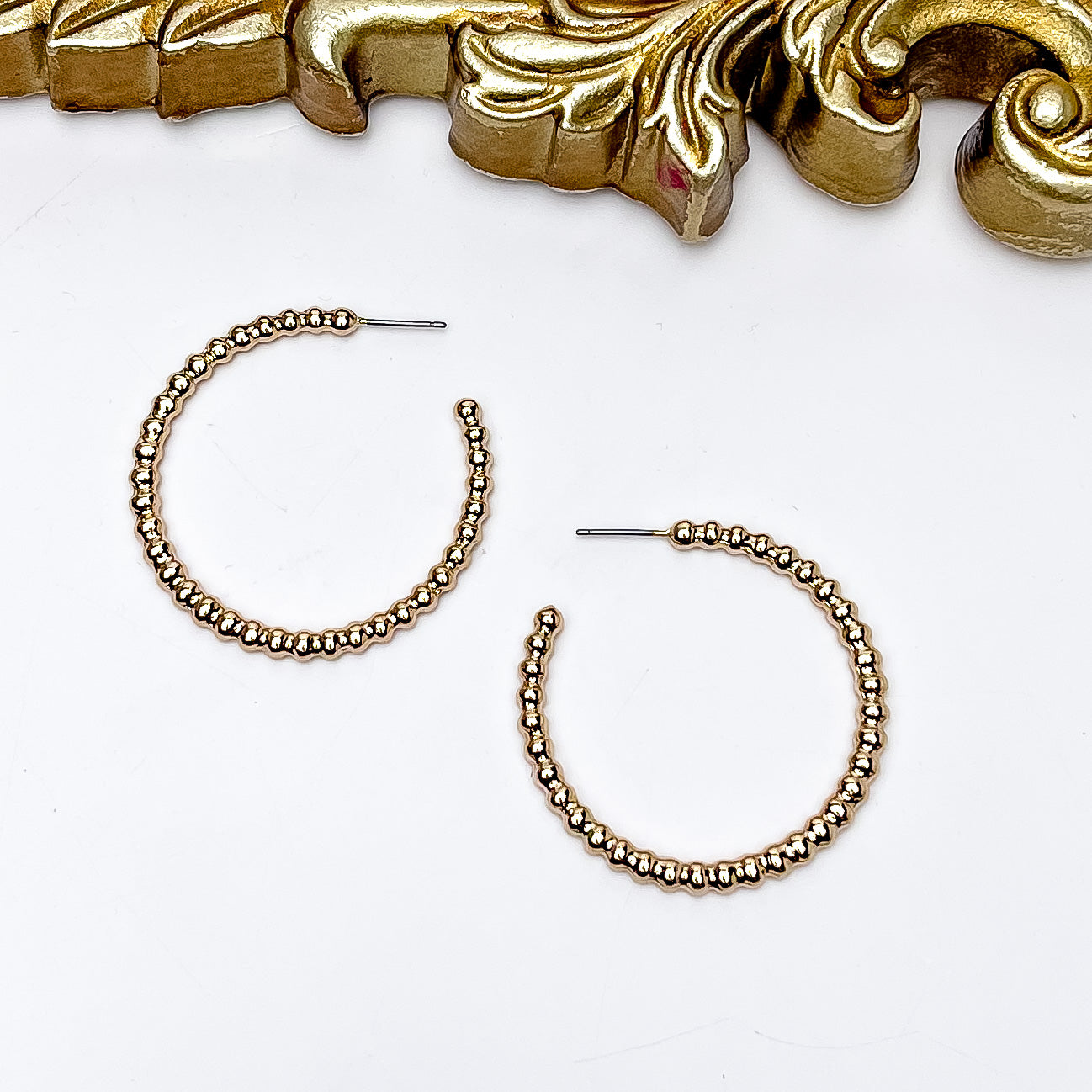 Gold Tone Connecting Beads Hoop Earrings. Pictured on a white background with a gold frame above the earrings.