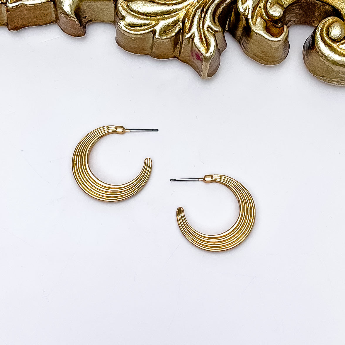 Livin' Life Gold Tone Small Hoop Earrings. Pictured on a white background with a gold frame above the earrings.