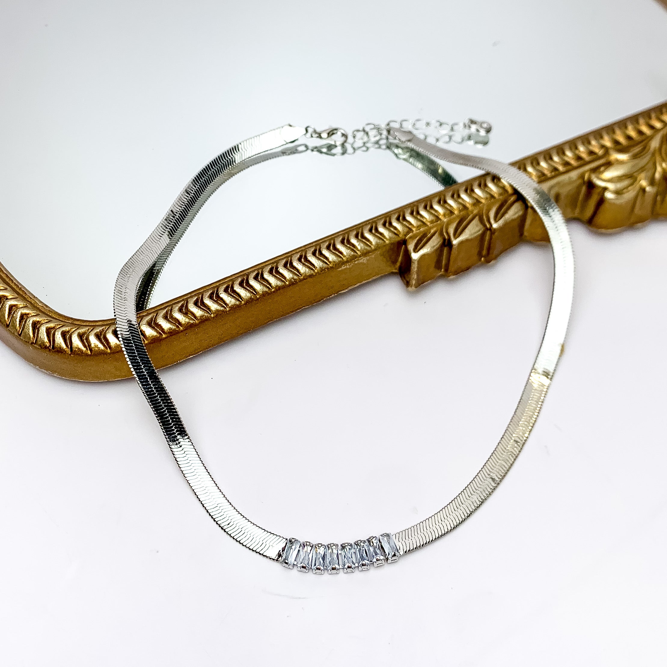 Silver Tone Chain Necklace With Rectangle Clear Crystals. Pictured on a white background with the top part of the necklace on a gold trim mirror.