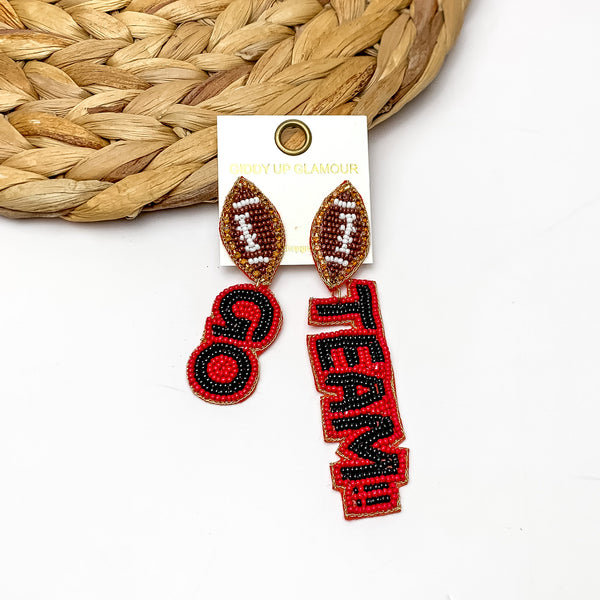 " Go Team!!" Beaded Earrings With Football Posts in Black and Red. These earrings are laying against a woven piece with a white background behind it.