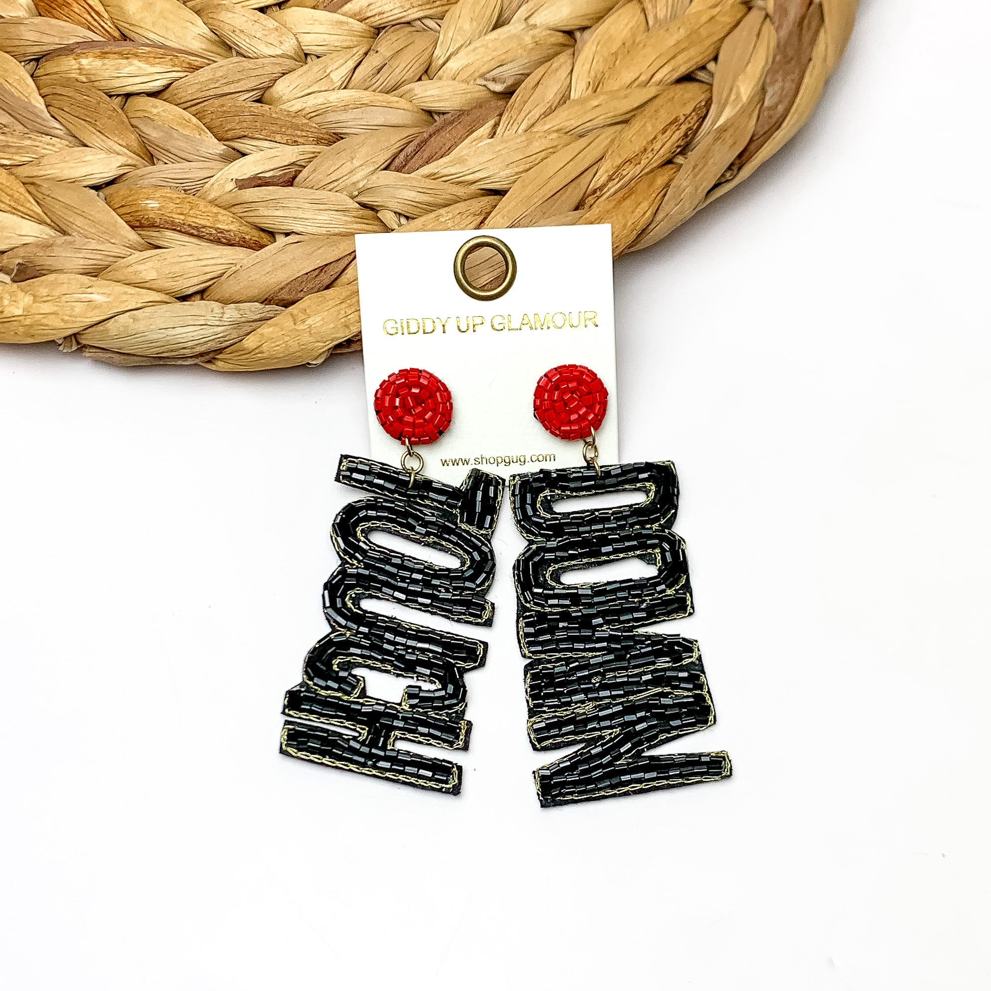 Beaded Touch Down Post Back Earrings in Black and Red. The earrings are laying against a woven piece. The background of the picture is white.