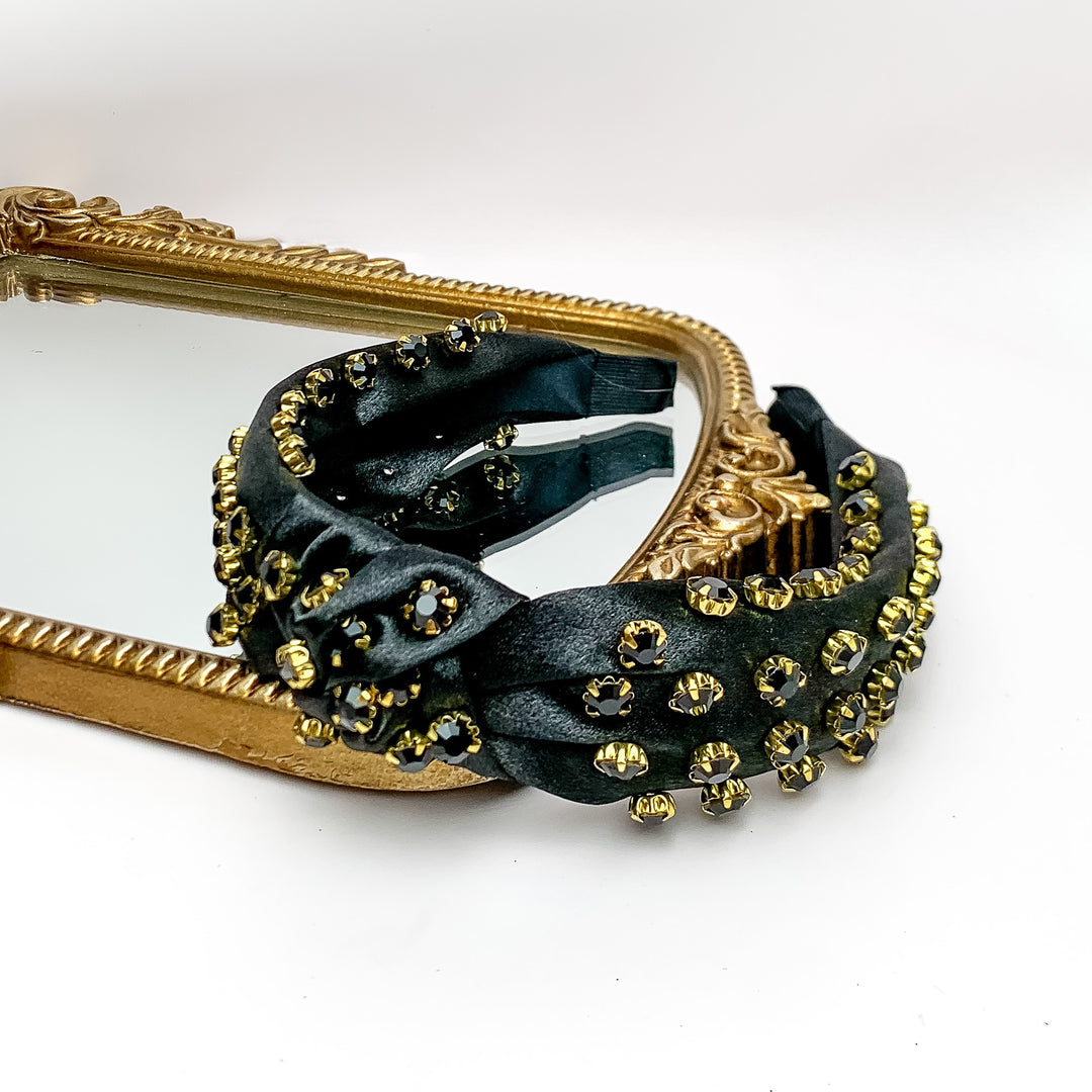 Crystal Detailed Knot Headband in Black. Pictured on a white background with the headband on a gold trimmed mirror.