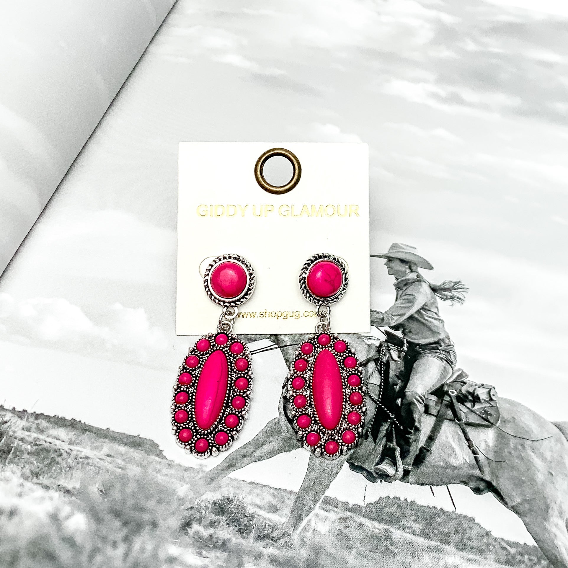 Circle Post Earrings with Oval Cluster and Stones in Hot Pink. Pictured on a book with a western background.