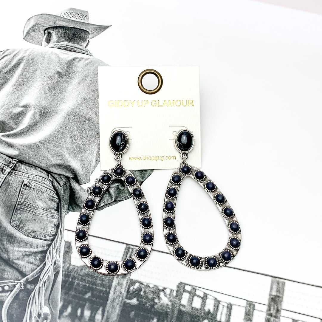 Western Open Teardrop Earrings With Stones in Black. Pictured on a western background picture.