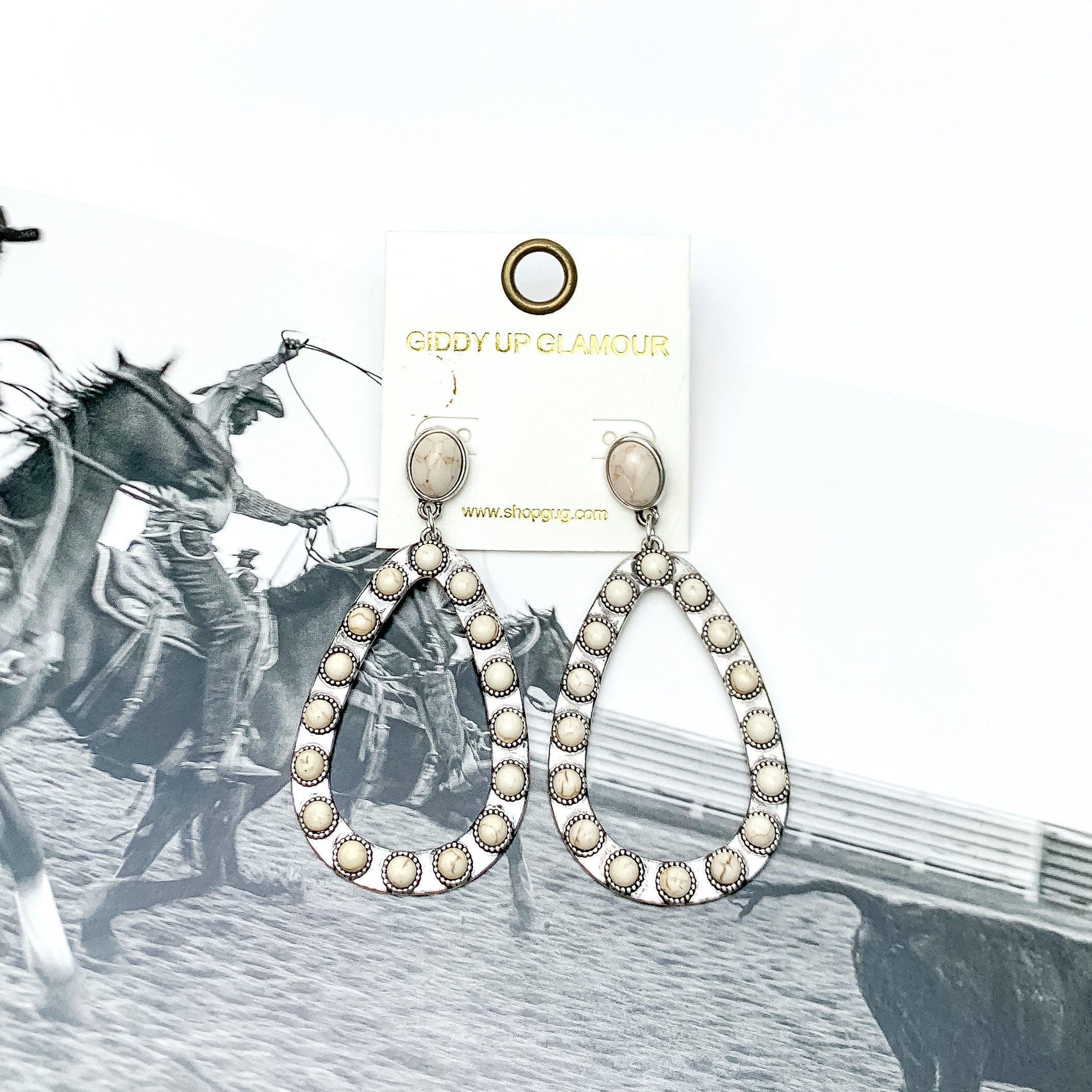 Western Open Teardrop Earrings With Stones in Ivory. Pictured on a western background picture.