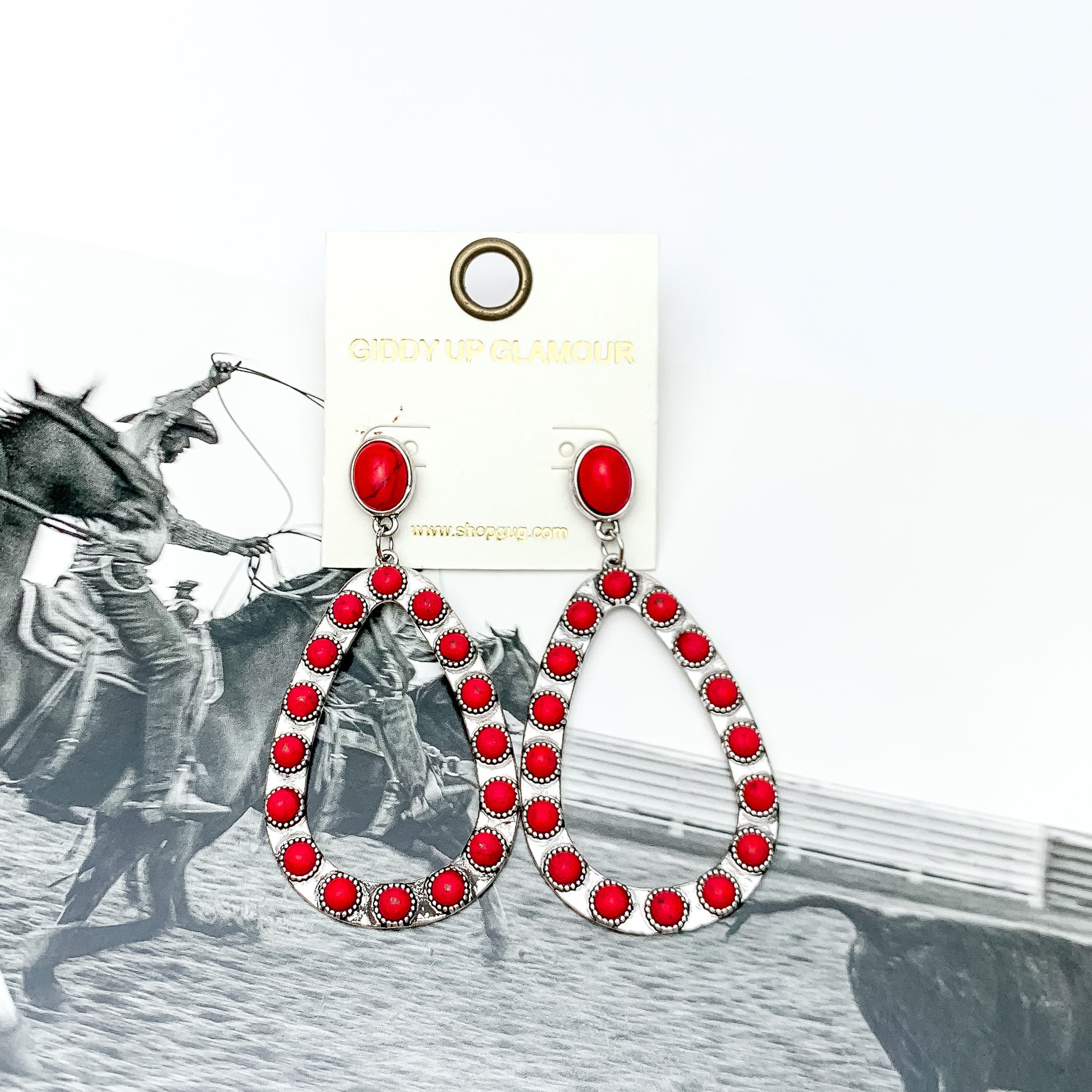 Western Open Teardrop Earrings With Stones in Red. Pictured on a western background picture.