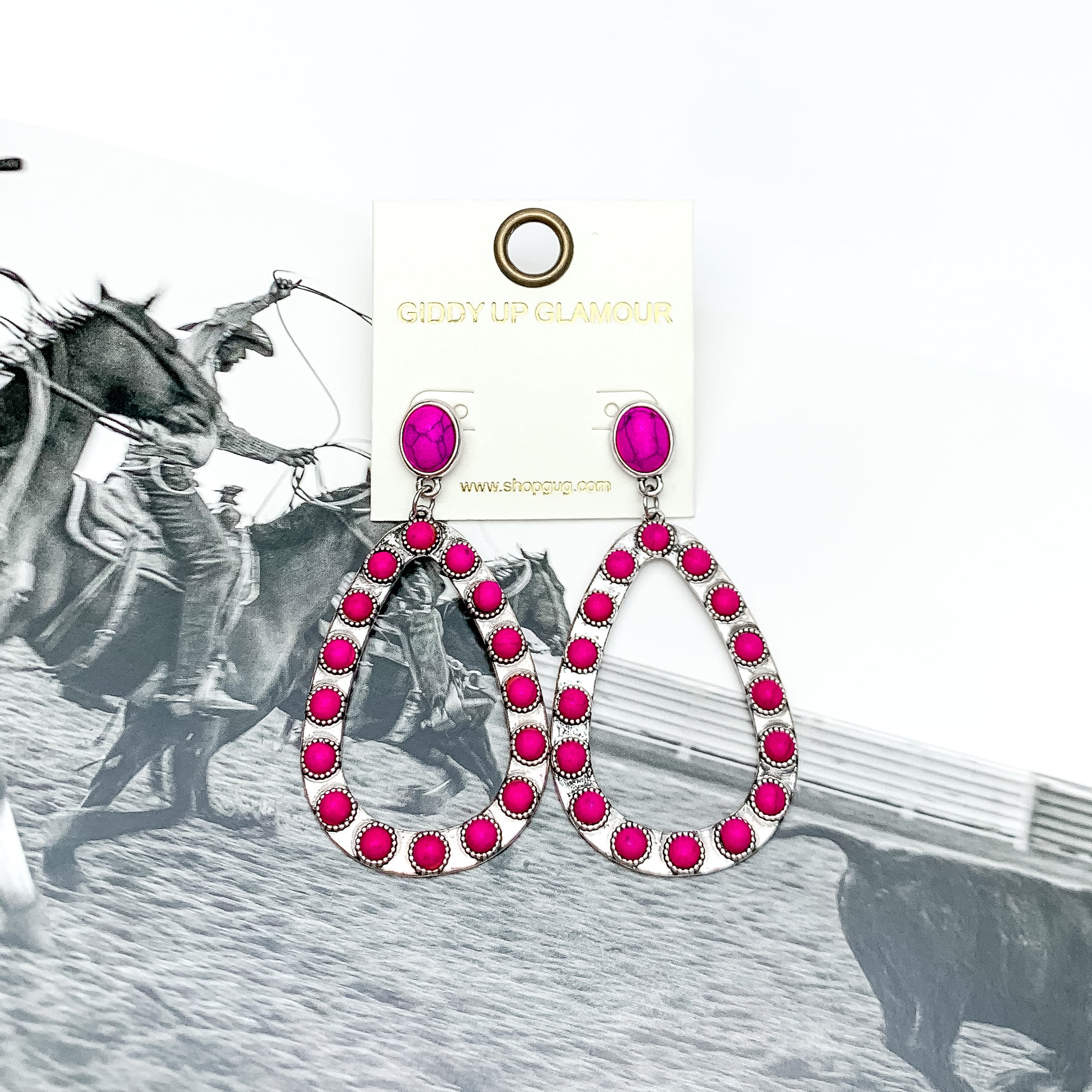 Western Open Teardrop Earrings With Stones in Hot Pink. Pictured on a western background picture.