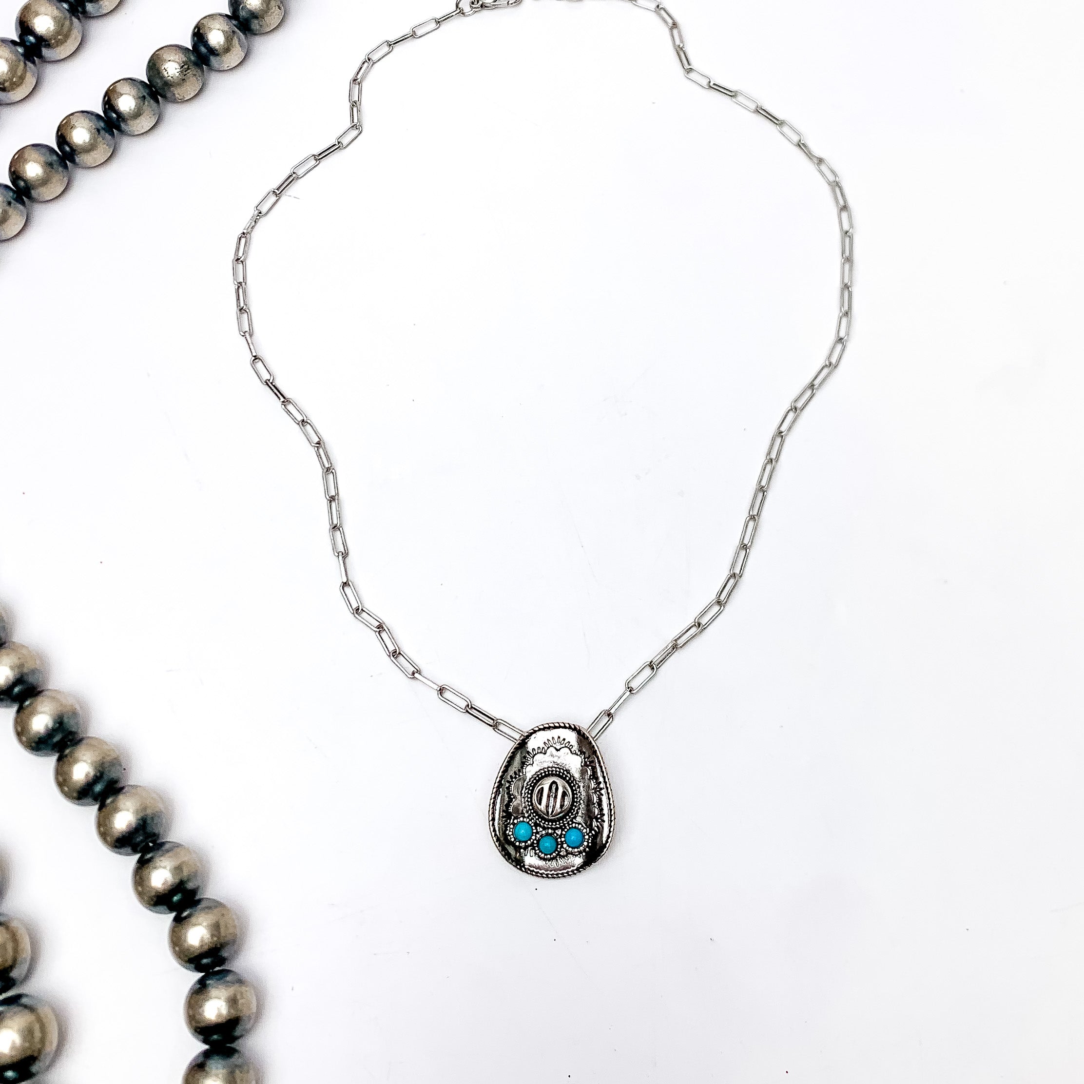 Cowgirl Chain Silver Tone Necklace With Cowboy Hat Pendent. Pictured on a white background with Navajo beads to the left of the necklace.