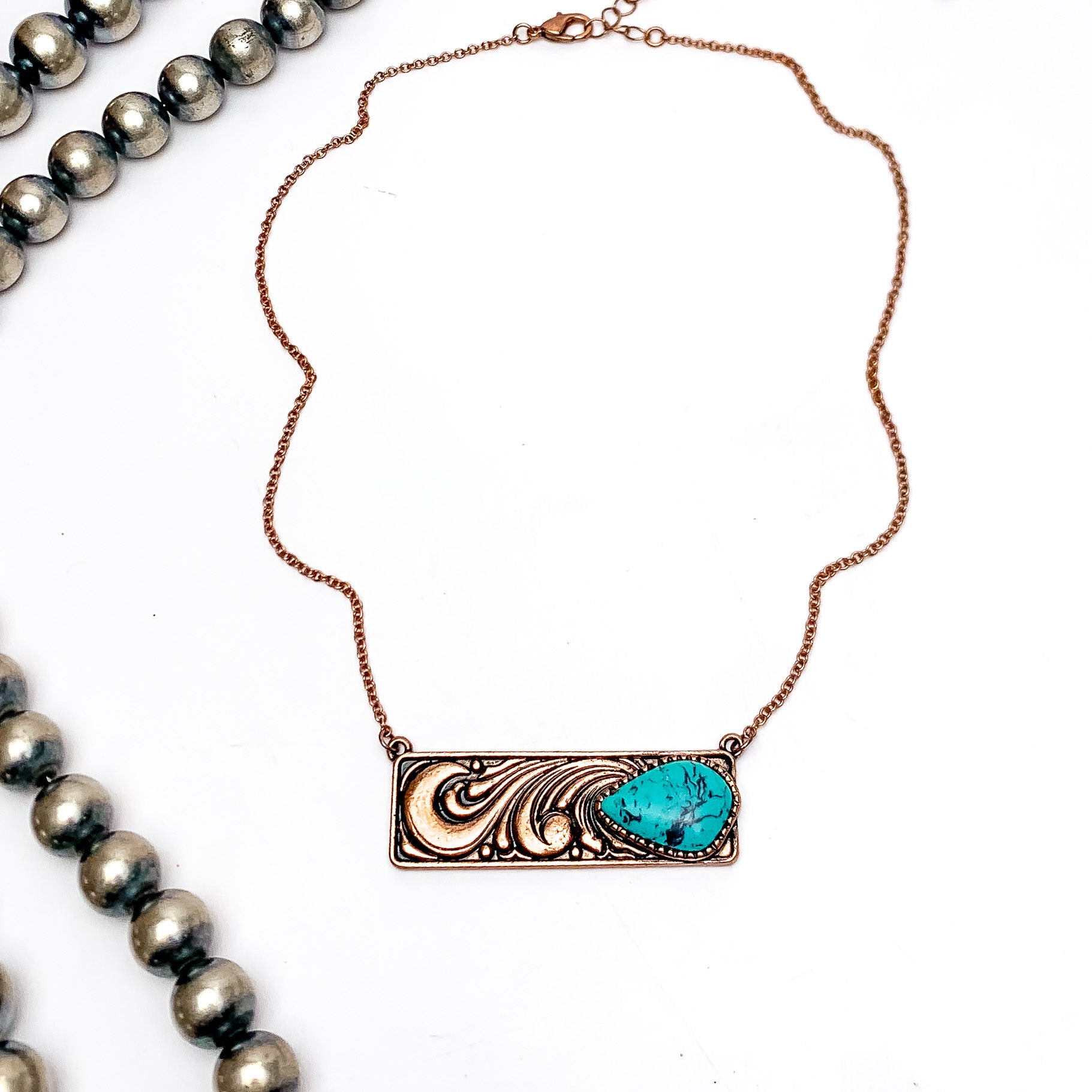 Western Swirl Copper Tone Necklace With Bar Pendent and Turquoise Stone. This necklace is pictured on a white background with Navajo pearls on the left side.