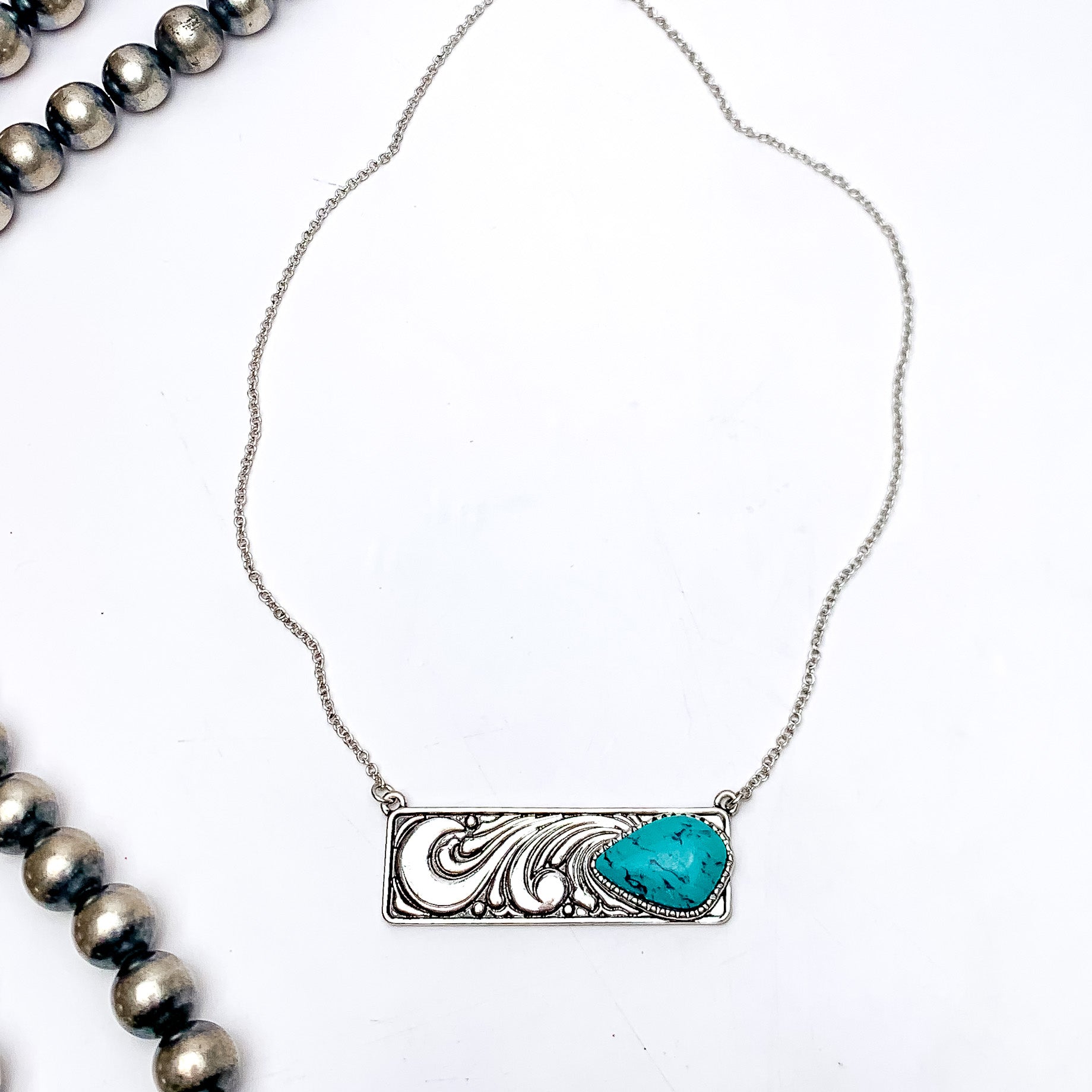 Western Swirl Silver Tone Necklace With Bar Pendent and Turquoise Stone. This necklace is pictured on a white background with Navajo pearls on the left side.