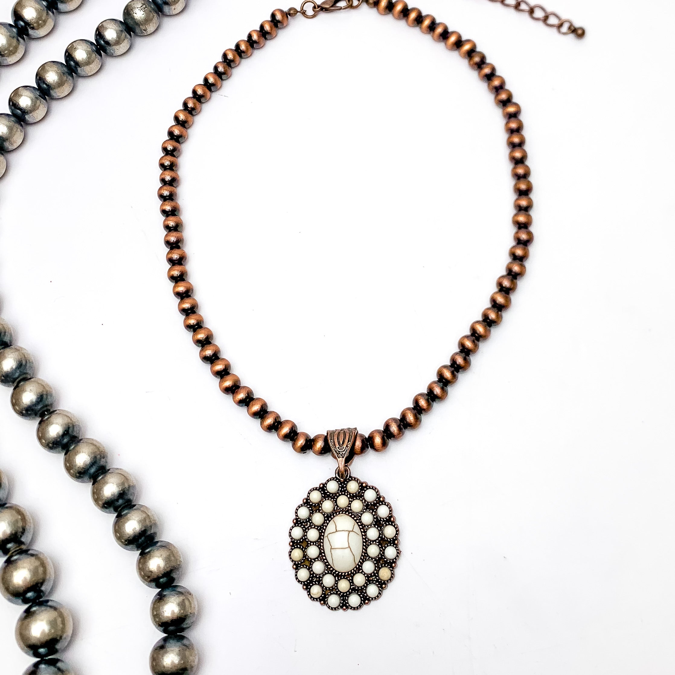 Copper Tone Pearl Necklace With Stone Cluster Pendent in Ivory. Pictured on a white background with Navajo pearls on the left side of the necklace.