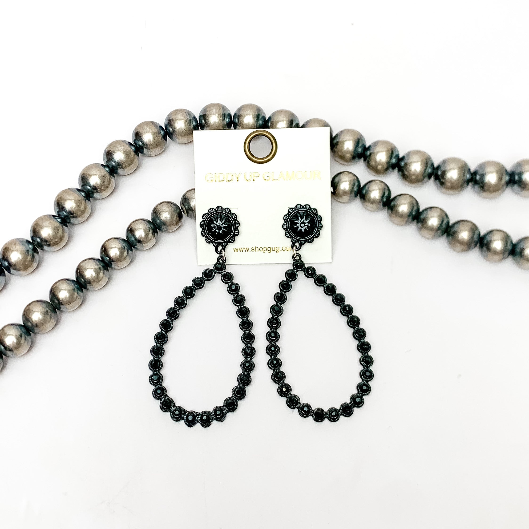 AB Crystal Open Teardrop Earrings in Black. These open ab crystal teardrop earrings are pictured on a white background with Navajo pearls behind the earrings.