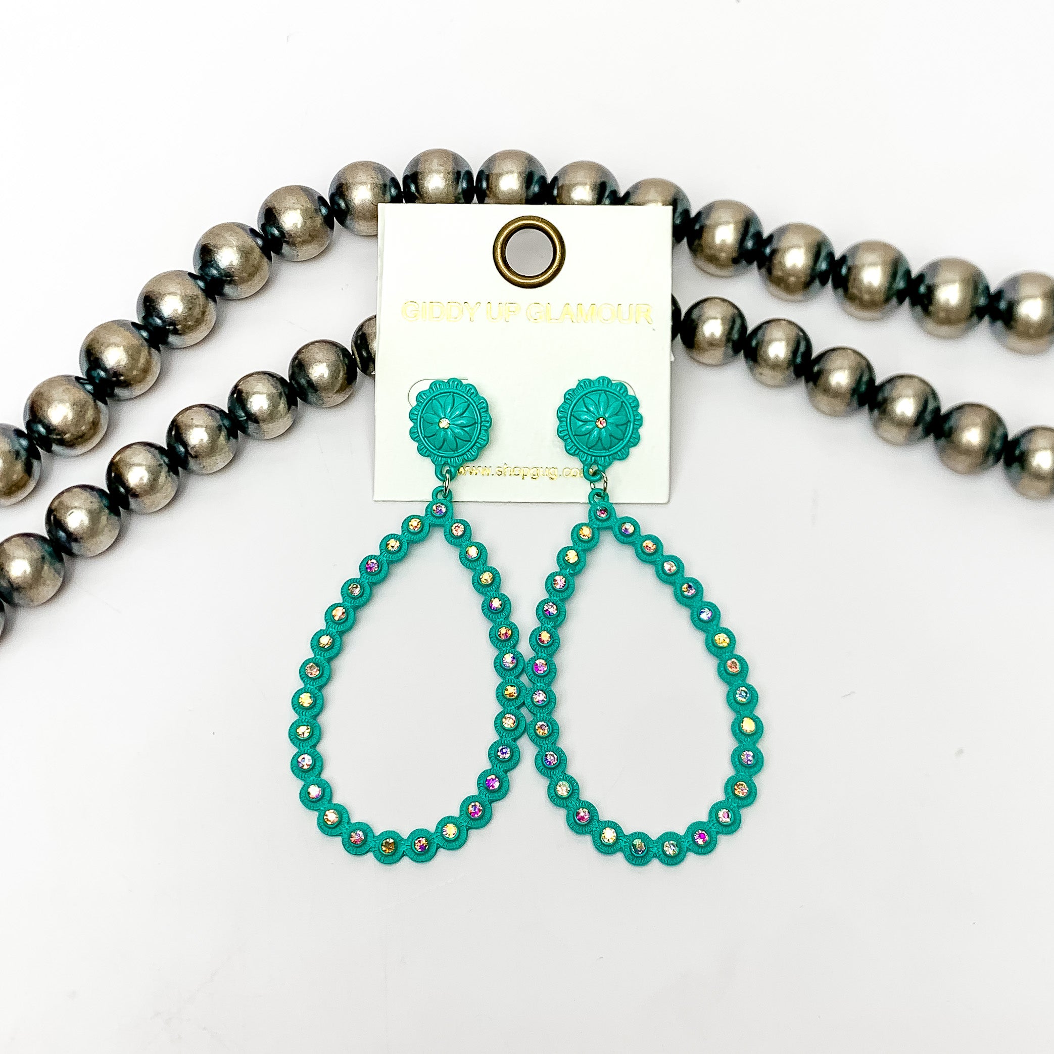 AB Crystal Open Teardrop Earrings in Turquoise Blue. These open ab crystal teardrop earrings are pictured on a white background with Navajo pearls behind the earrings.