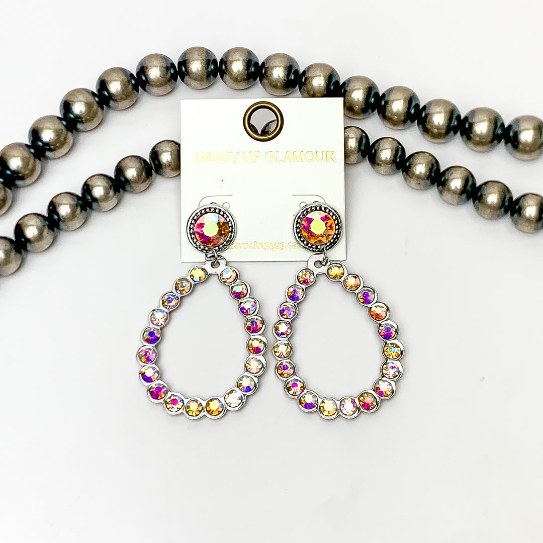 Glitzy Girl AB Crystal Teardrop Earrings in Silver. Pictured on a white background with Navajo pearls behind the earrings.