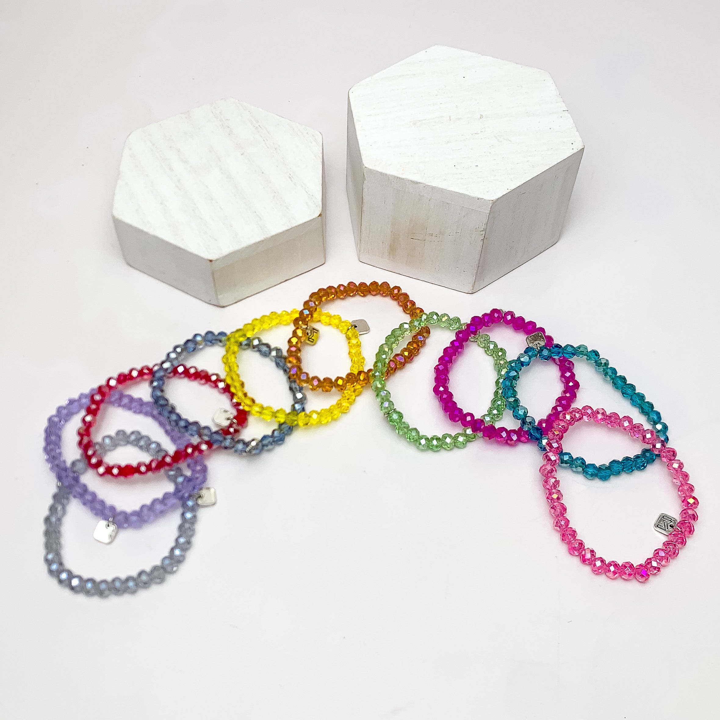 Set of Ten | Party Girl Crystal Beaded Bracelet Set in Light Multicolor. These bracelets are pictured on a white background with two white podiums behind the bracelets.