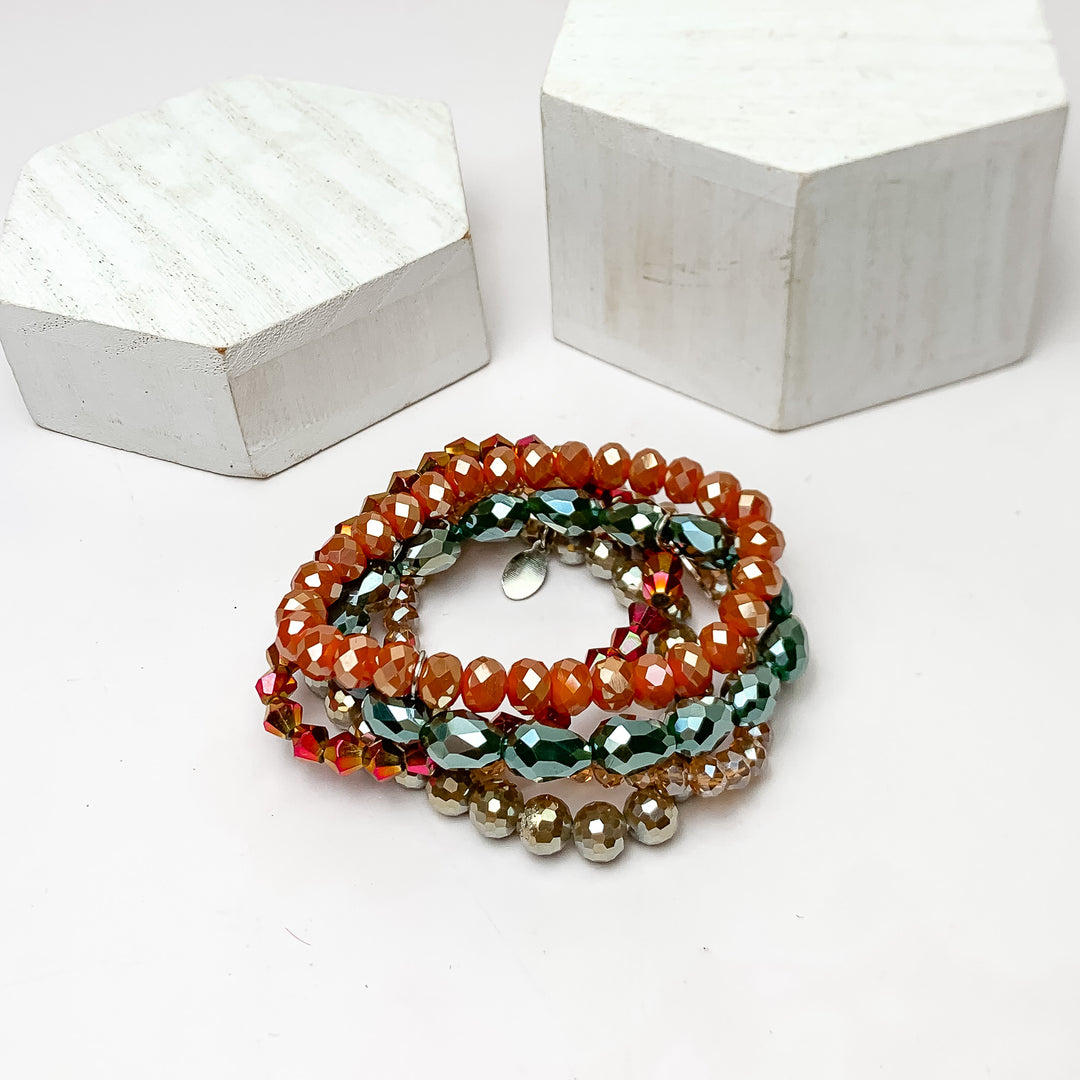 Set of Five | All Nighter Crystal Beaded Bracelet Set in Red and Blue Tones. These bracelets are pictured on a white background with two white podiums behind them.
