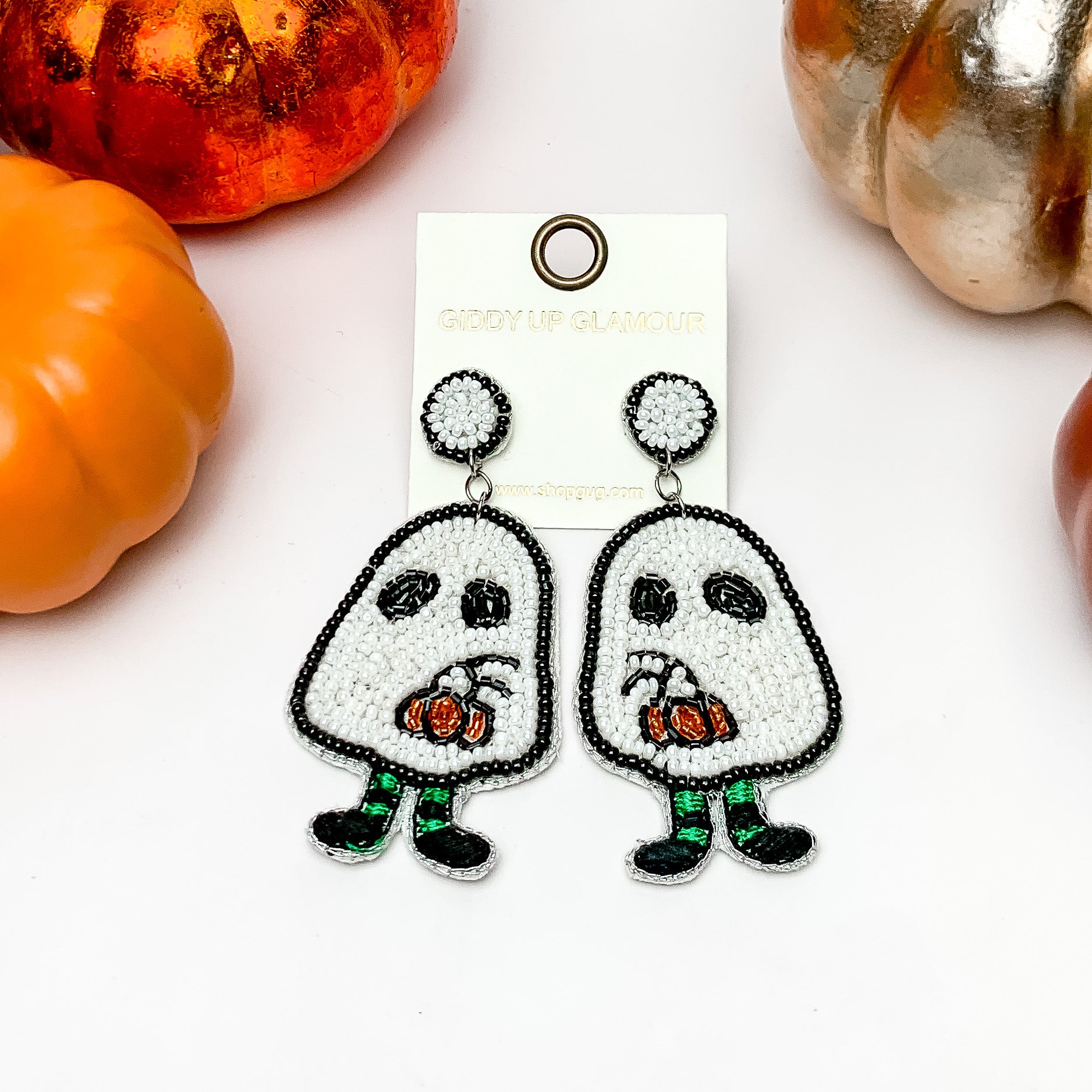Ghost Boy Beaded Earrings in White. These earrings are on a white background with orange and silver pumpkins around them.