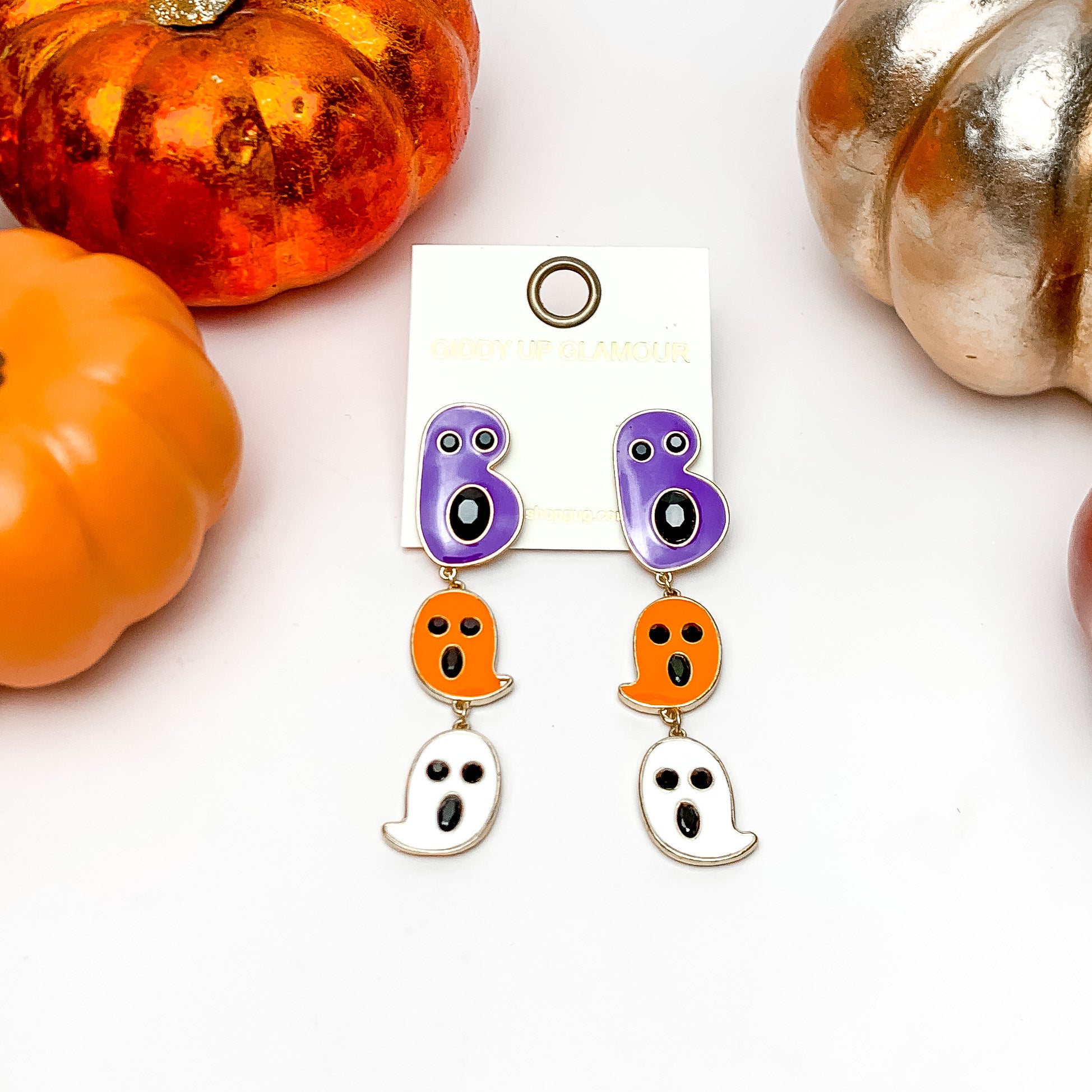 Ghost Drop Post Earrings with Black Crystals in Purple, Orange, and White. These earrings are on a white background with orange and silver pumpkins around them.