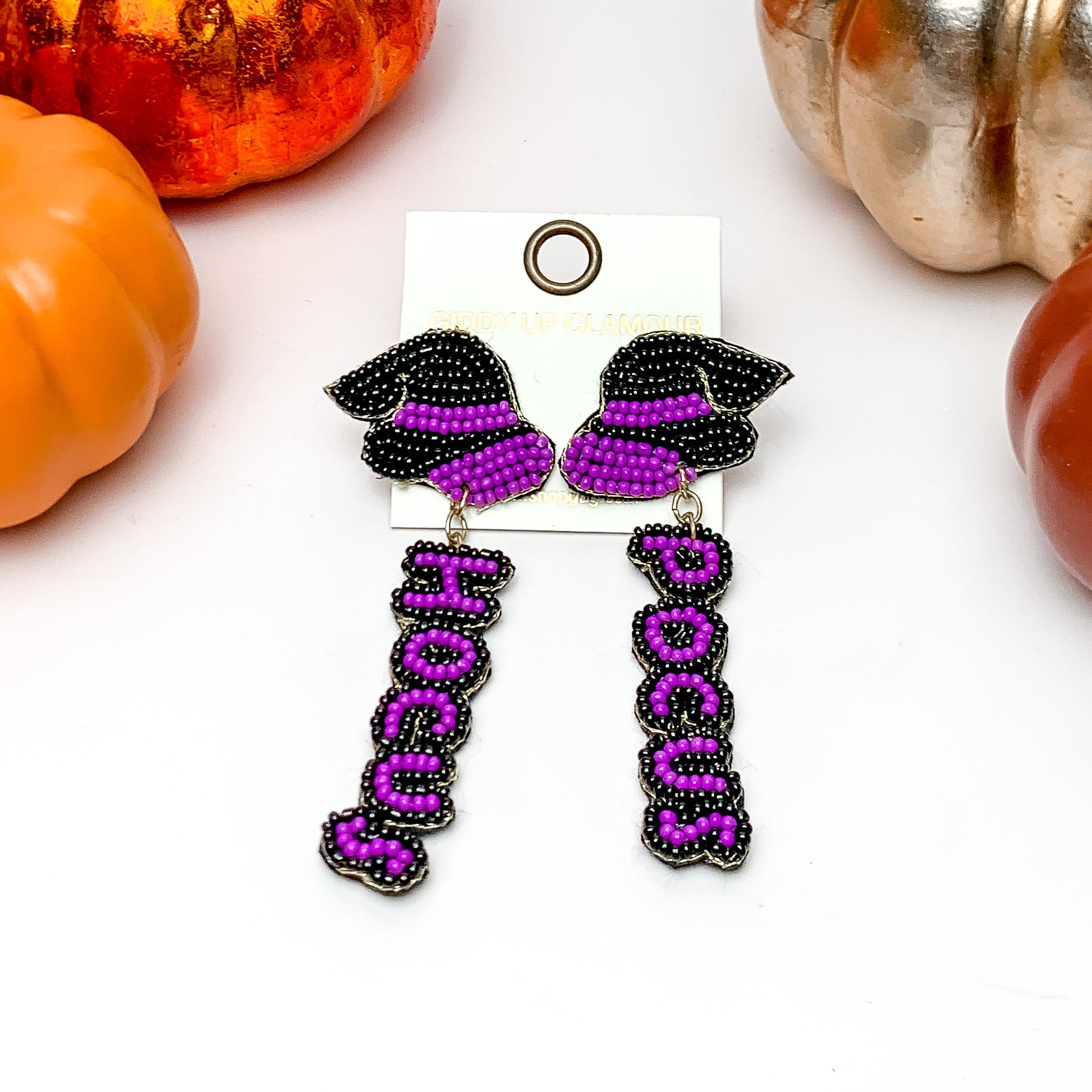 Hocus Pocus Beaded Earrings in Black and Purple. These earrings are on a white background with orange and silver pumpkins around them.