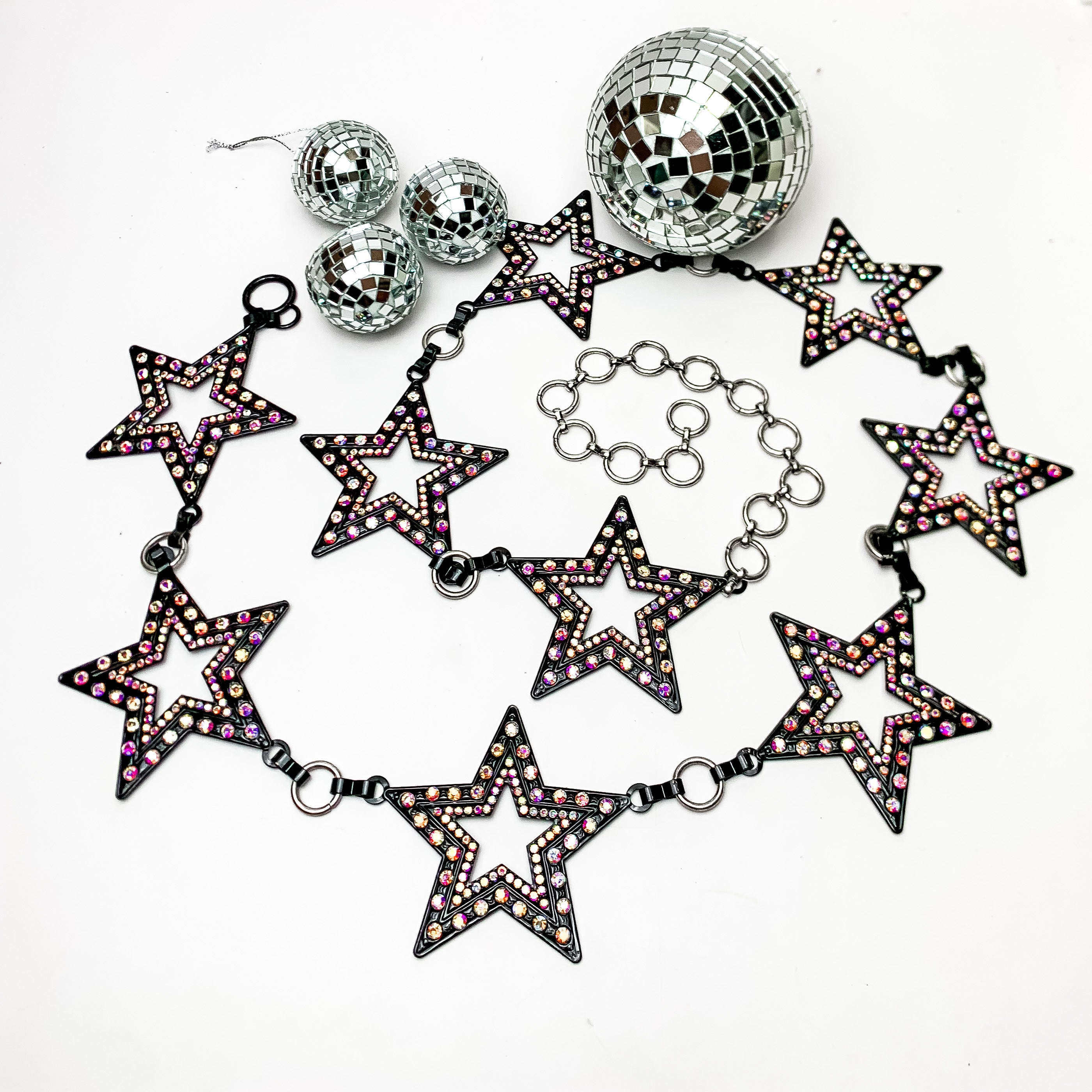 Starlight Adjustable Black Belt With Ab Crystals. This belt is on a white background with disco balls above them for decoration. 