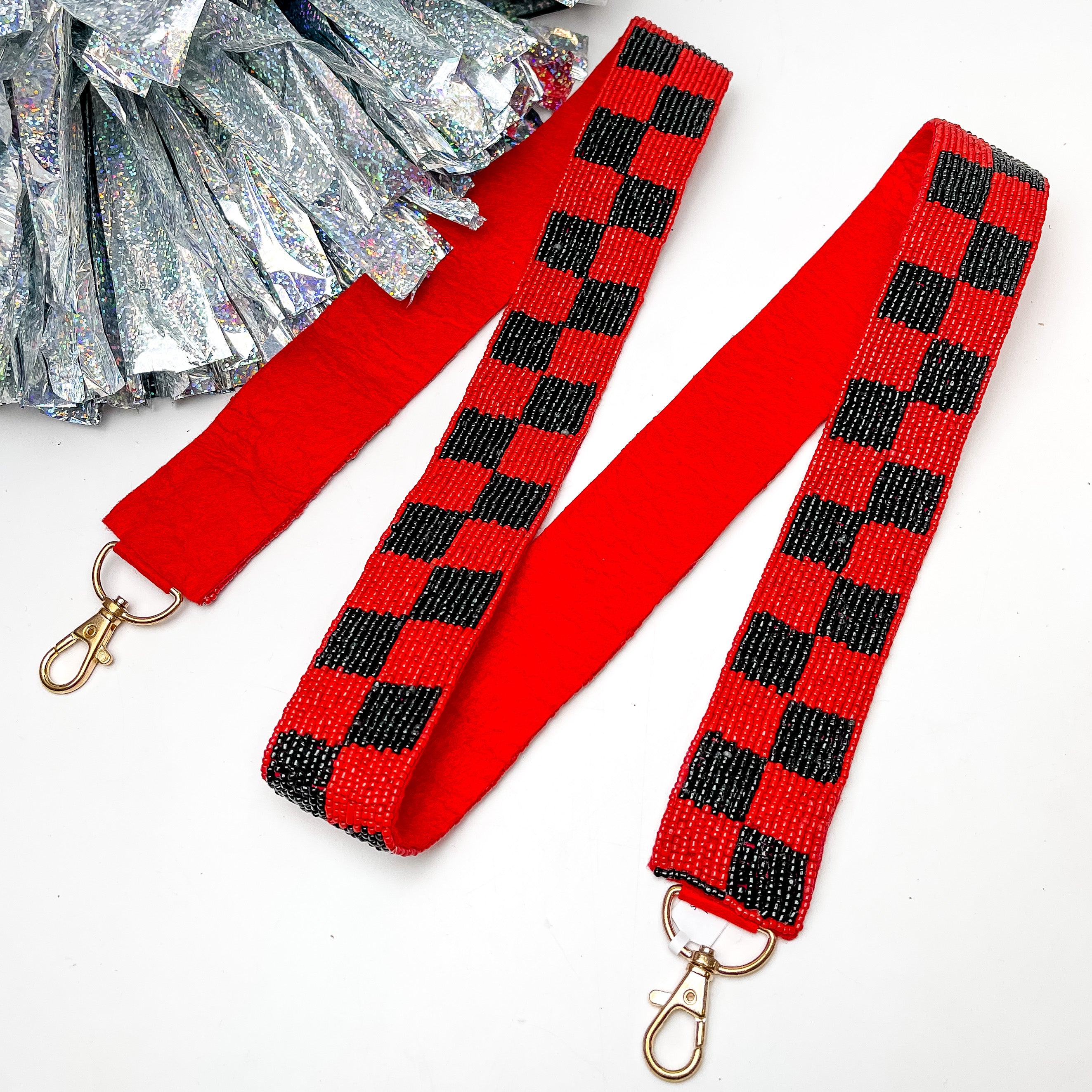 Game Day! Checkered Beaded Purse Strap in Red and Black. This purse strap is pictured on a white background with a silver pom pom next to it.
