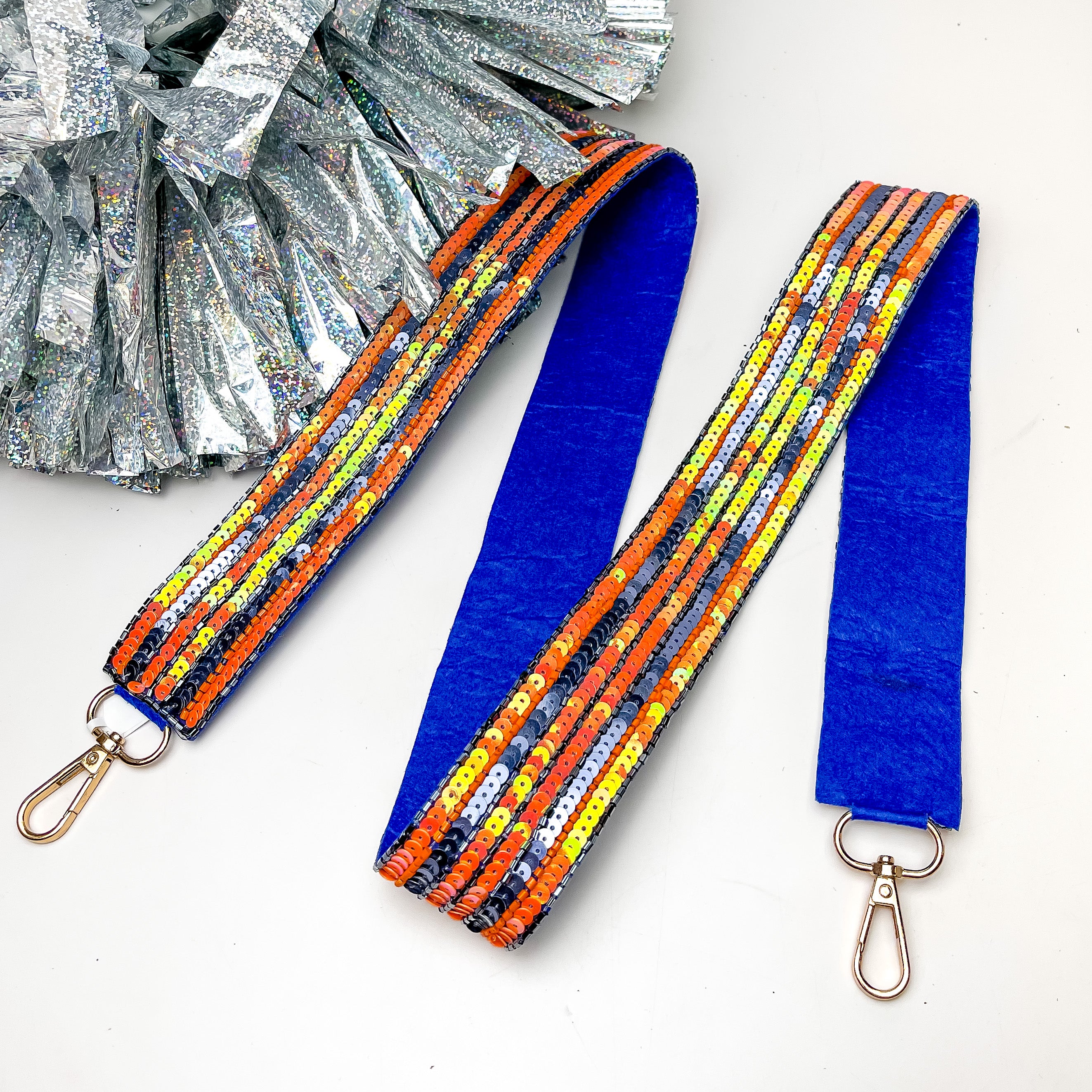 Game Day! Stripped Beaded Purse Strap in Orange and Blue. This purse strap is pictured on a white background with a silver pom pom next to it.