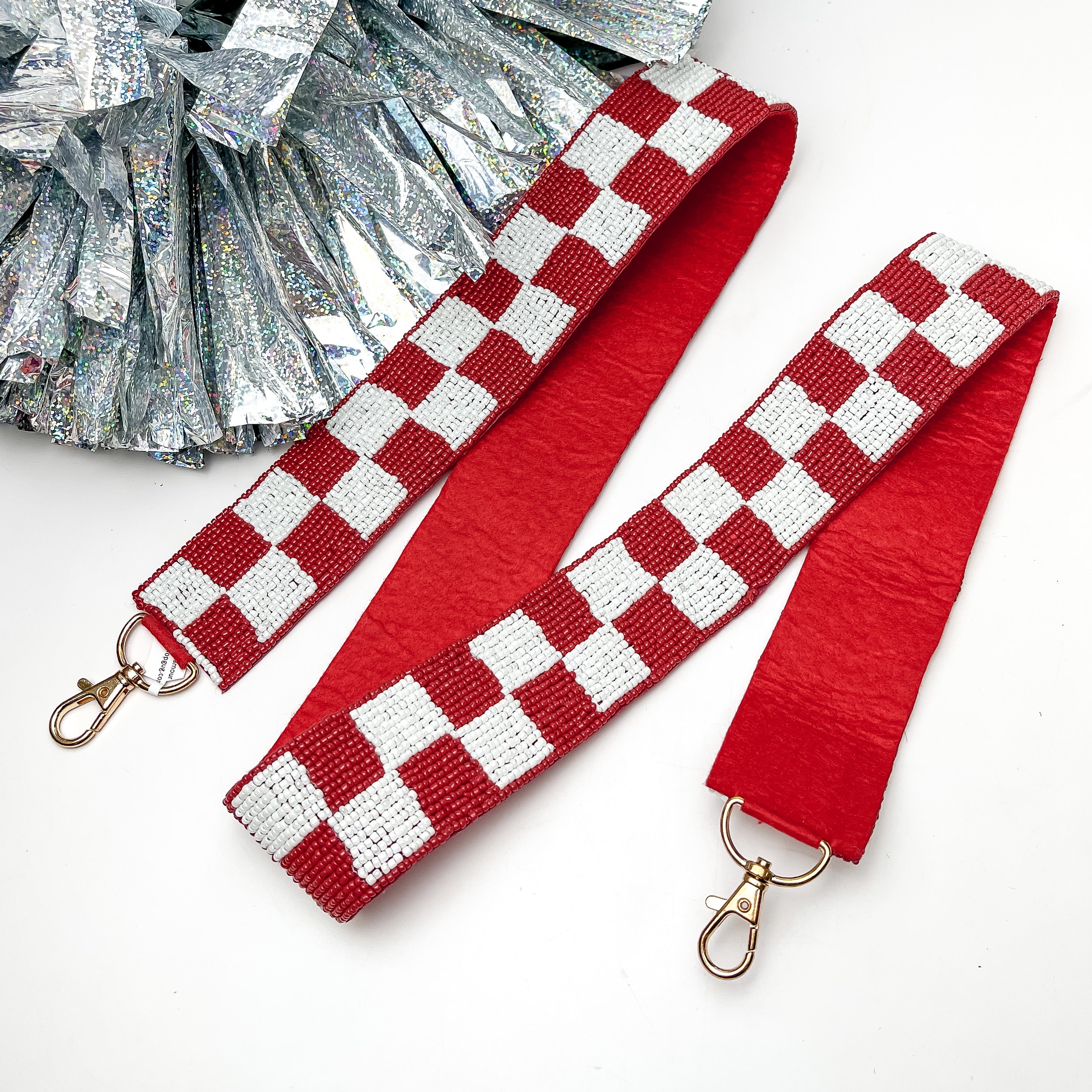 Game Day! Checkered Beaded Purse Strap in Red and White. This purse strap is pictured on a white background with a silver pom pom next to it.