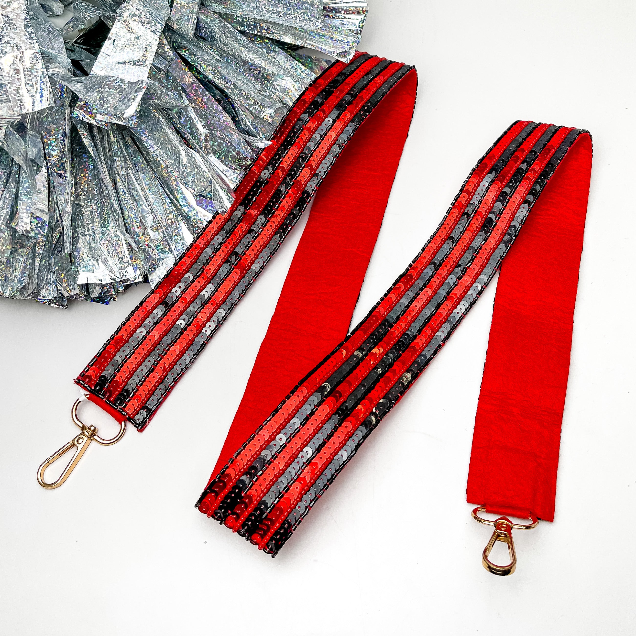 Game Day! Striped Beaded Purse Strap in Red and Black. This purse strap is pictured on a white background with a silver pom pom next to it.