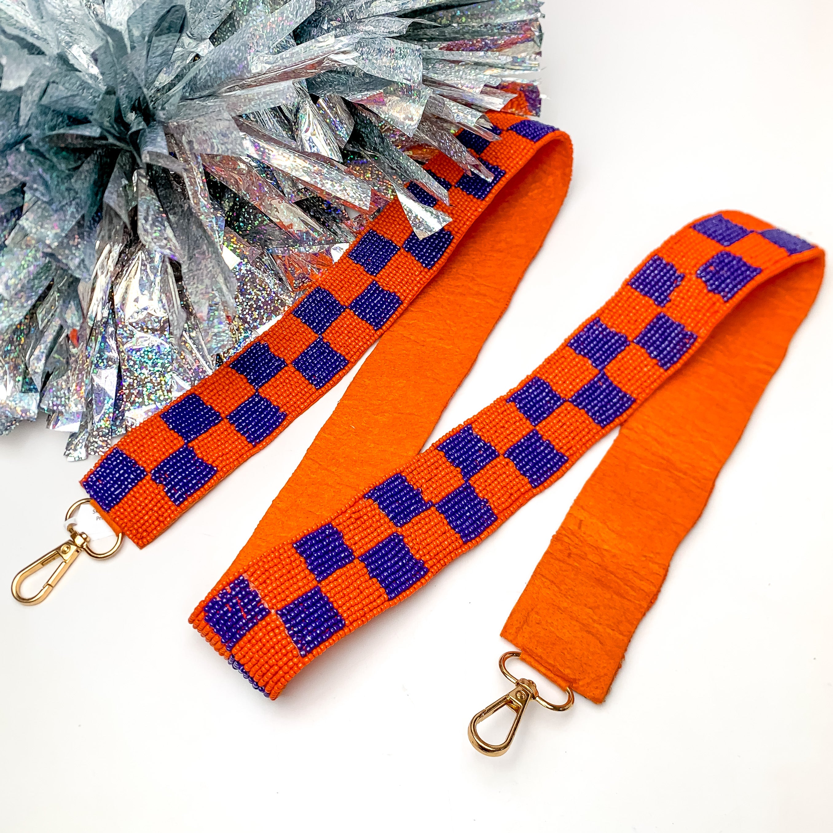 Game Day! Checkered Beaded Purse Strap in Orange and Blue. This purse strap is pictured on a white background with a silver pom pom next to it.