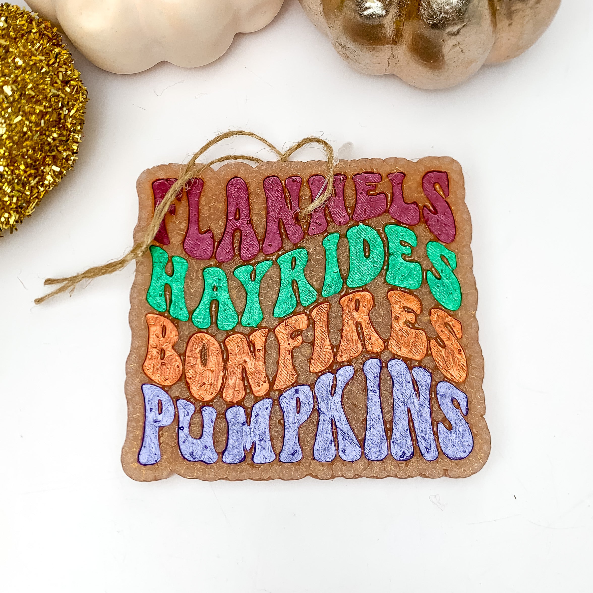 "Flannels Hayrides Bonfires Pumpkins" Freshie in Butter Pecan Waffles. This freshie is pictured on a white background with pumpkins above the freshie.