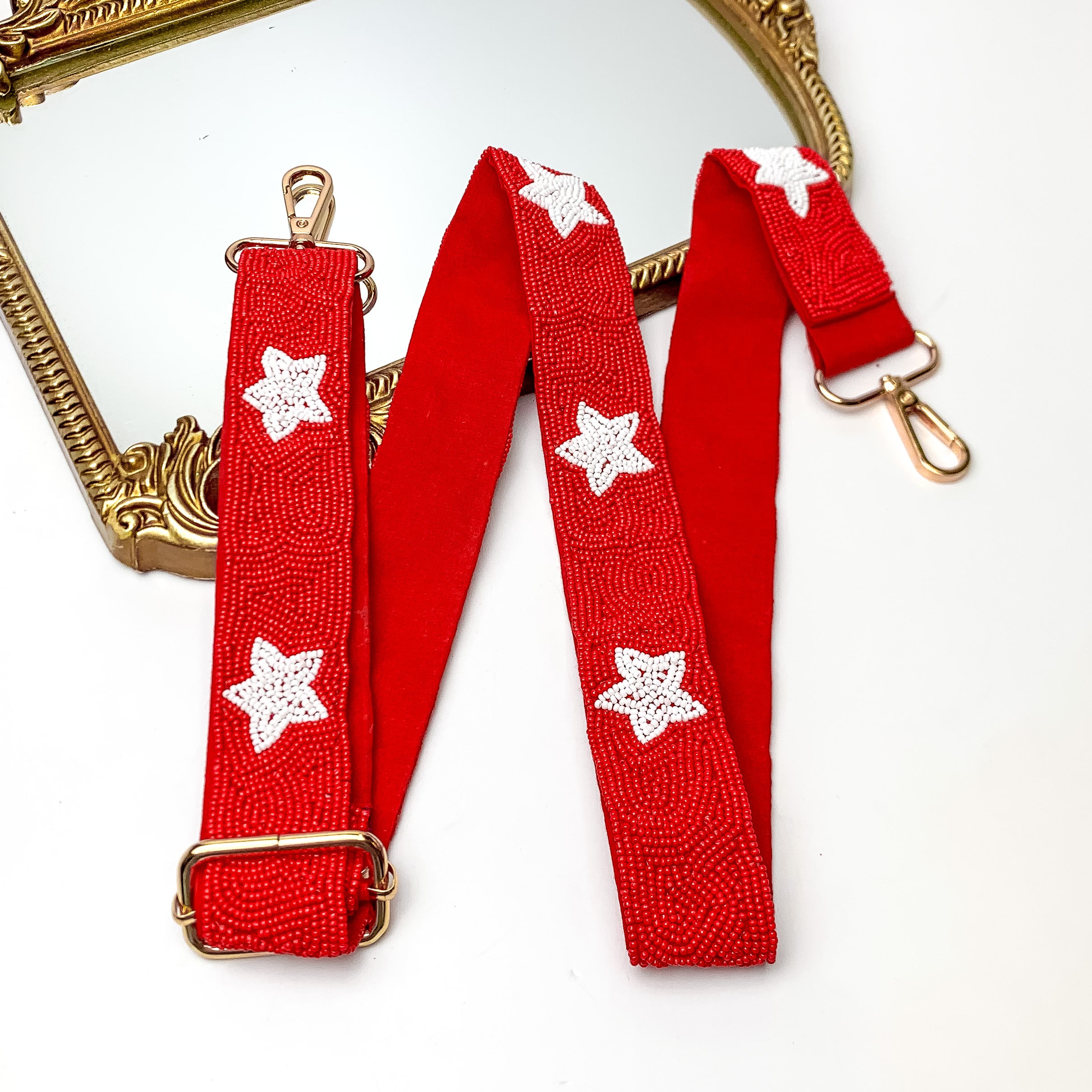 Star of the Show Beaded Adjustable Purse Strap in Red and White. This purse strap is pictured on a white background with a gold trimmed mirror in the corner.