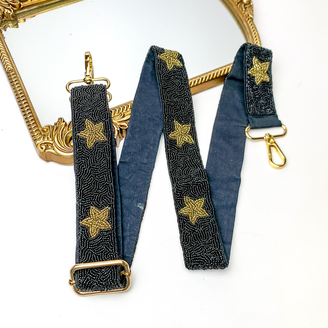 Star of the Show Beaded Adjustable Purse Strap in Black and Gold. This purse strap is pictured on a white background with a gold trimmed mirror in the corner.