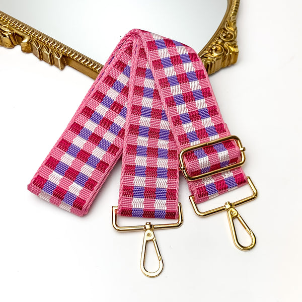 Checkered Adjustable Purse Strap in Pink, White, and Purple. This purse strap is pictured on a white background with a gold trimmed mirror in the corner.