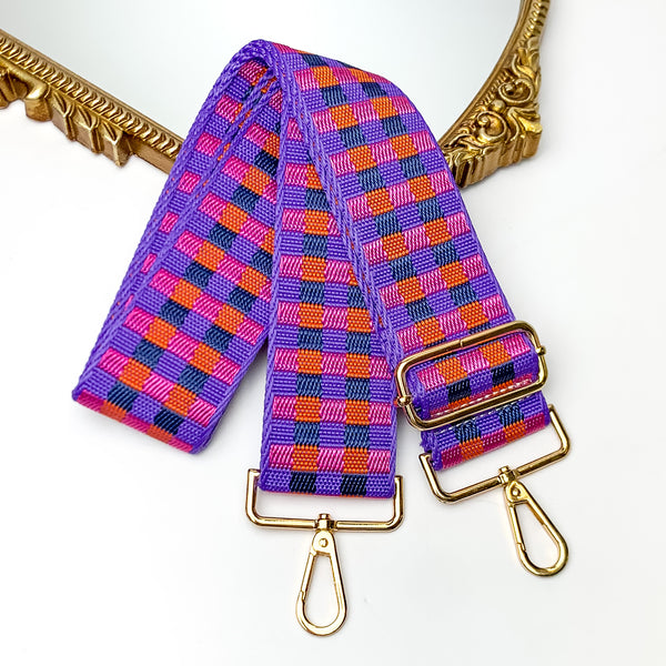 Checkered Adjustable Purse Strap in Purple, Orange, and Black. This purse strap is pictured on a white background with a gold trimmed mirror in the corner.