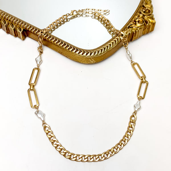 She's Pretty in Pearl Gold Tone Chain Necklace With Pearl Accents. This gold tone necklace with pearl accents is pictured on a white background with a gold mirror.