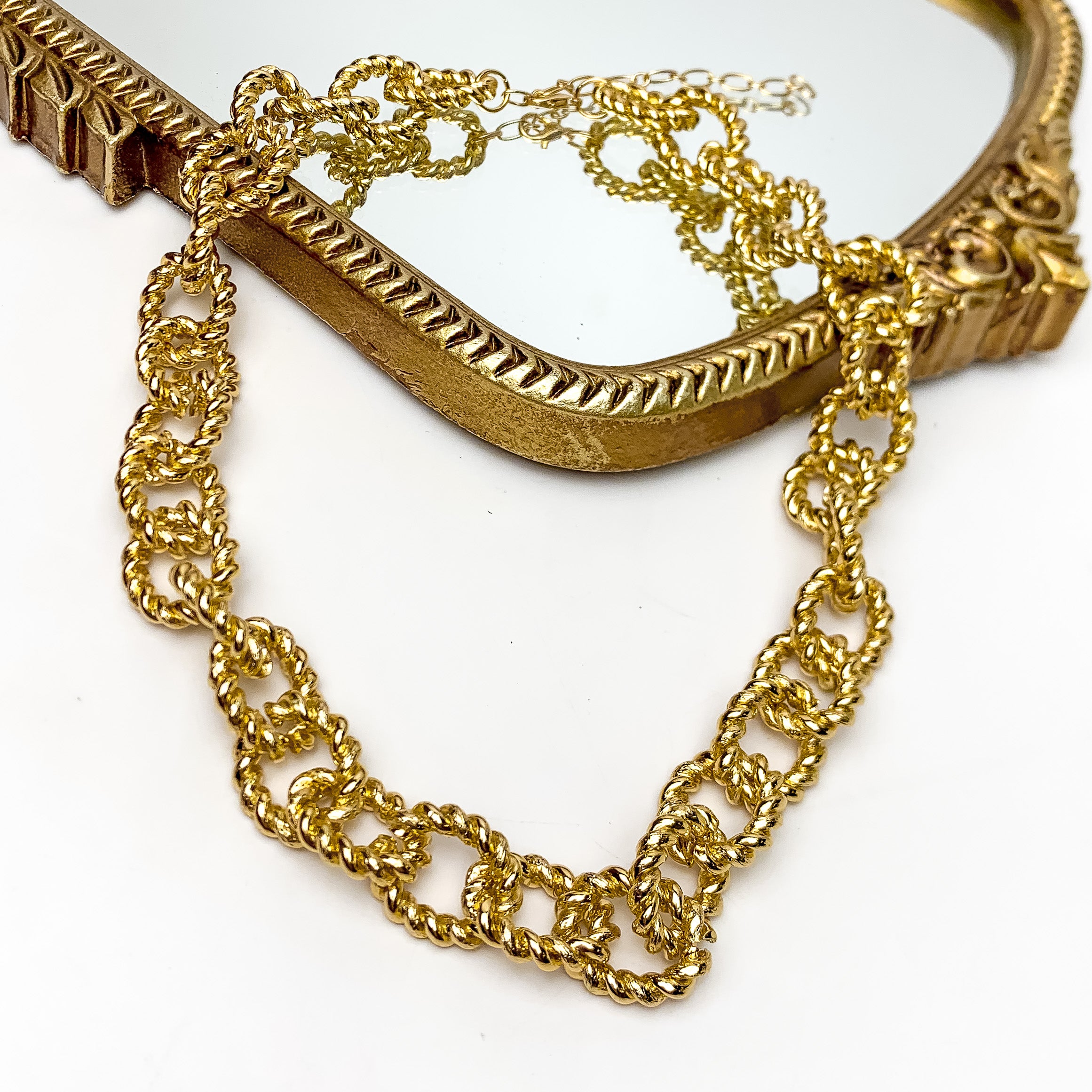 Fall Festivities Gold Tone Chain Necklace. This gold chained necklace is pictured on a white background with part of it laying on a mirror.