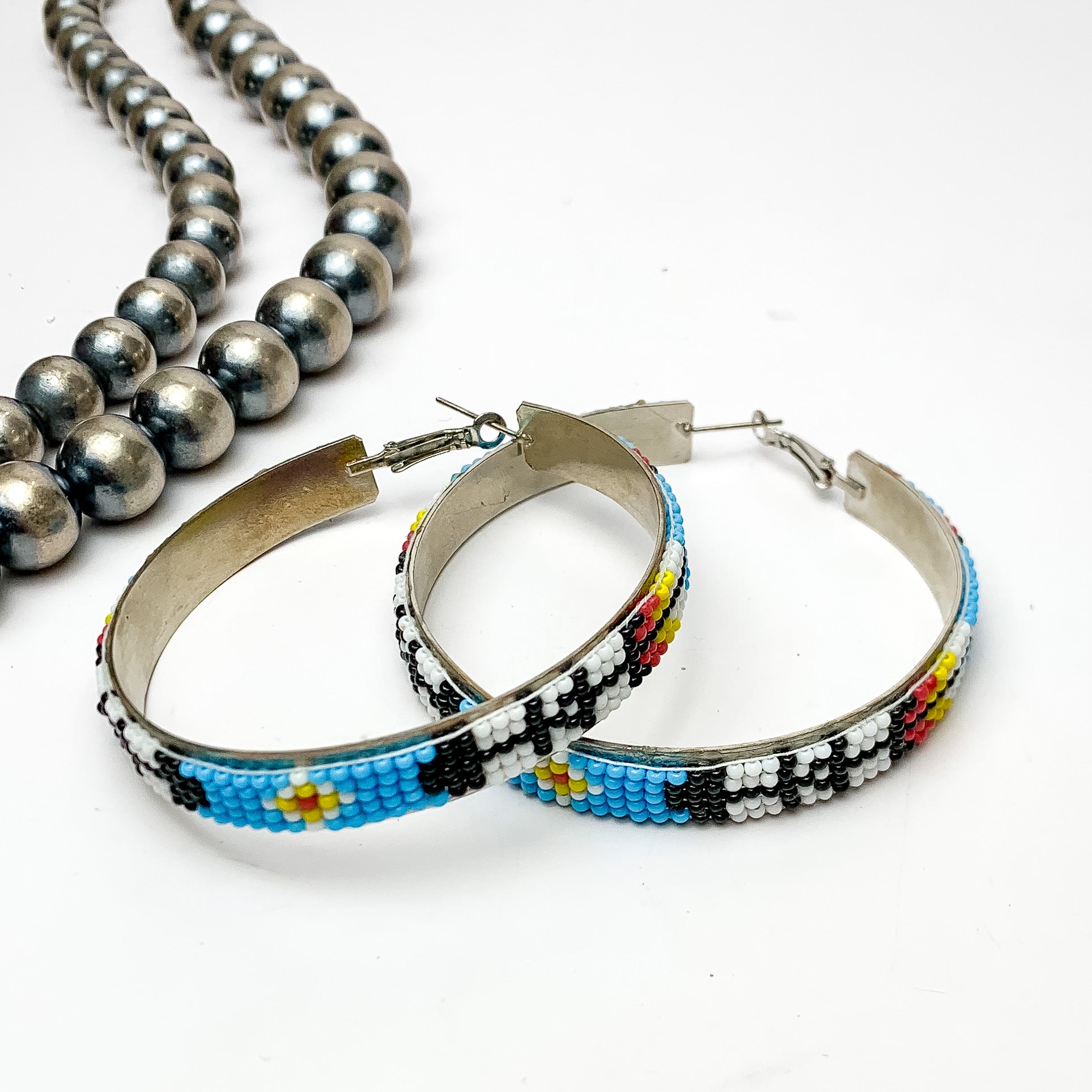 Aztec Pattern Beaded Hoop Earrings in Multicolor.  Pictured on a white background with Navajo pearls on the left side.