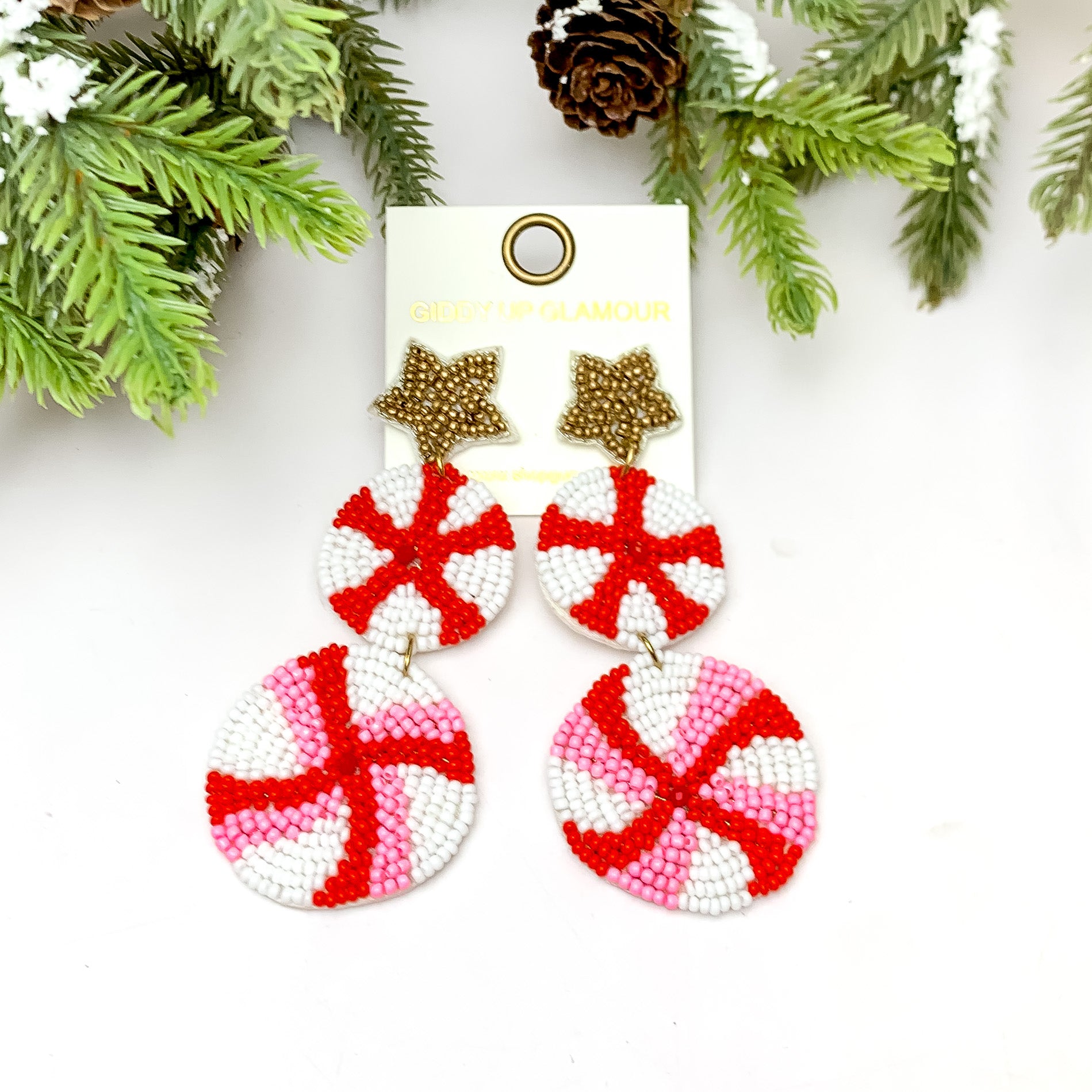 Christmas Colorful Dessert Lollipop Beaded Earrings. These earrings are pictured on a white background with a tree and pine cones at the top.