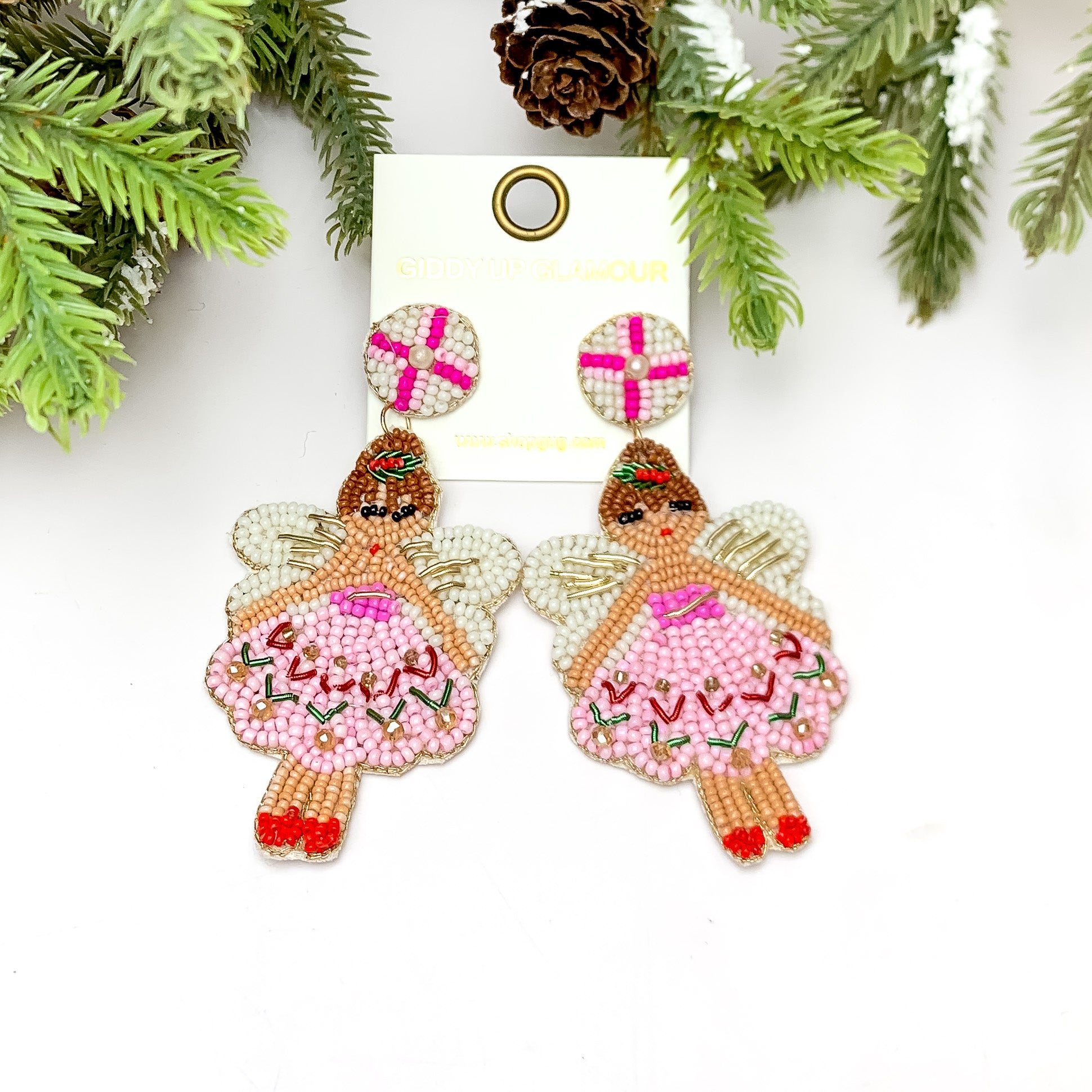 Beaded Christmas Fairy Earrings in Pink Tones. These earrings are pictured on a white background with a tree and pine cones at the top.