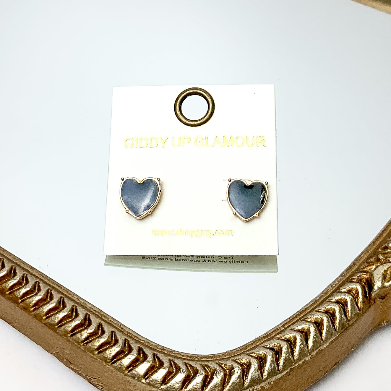 Gold Tone Heart Stud Earrings in Black. These earrings are pictured on a white background with a gold frame around.