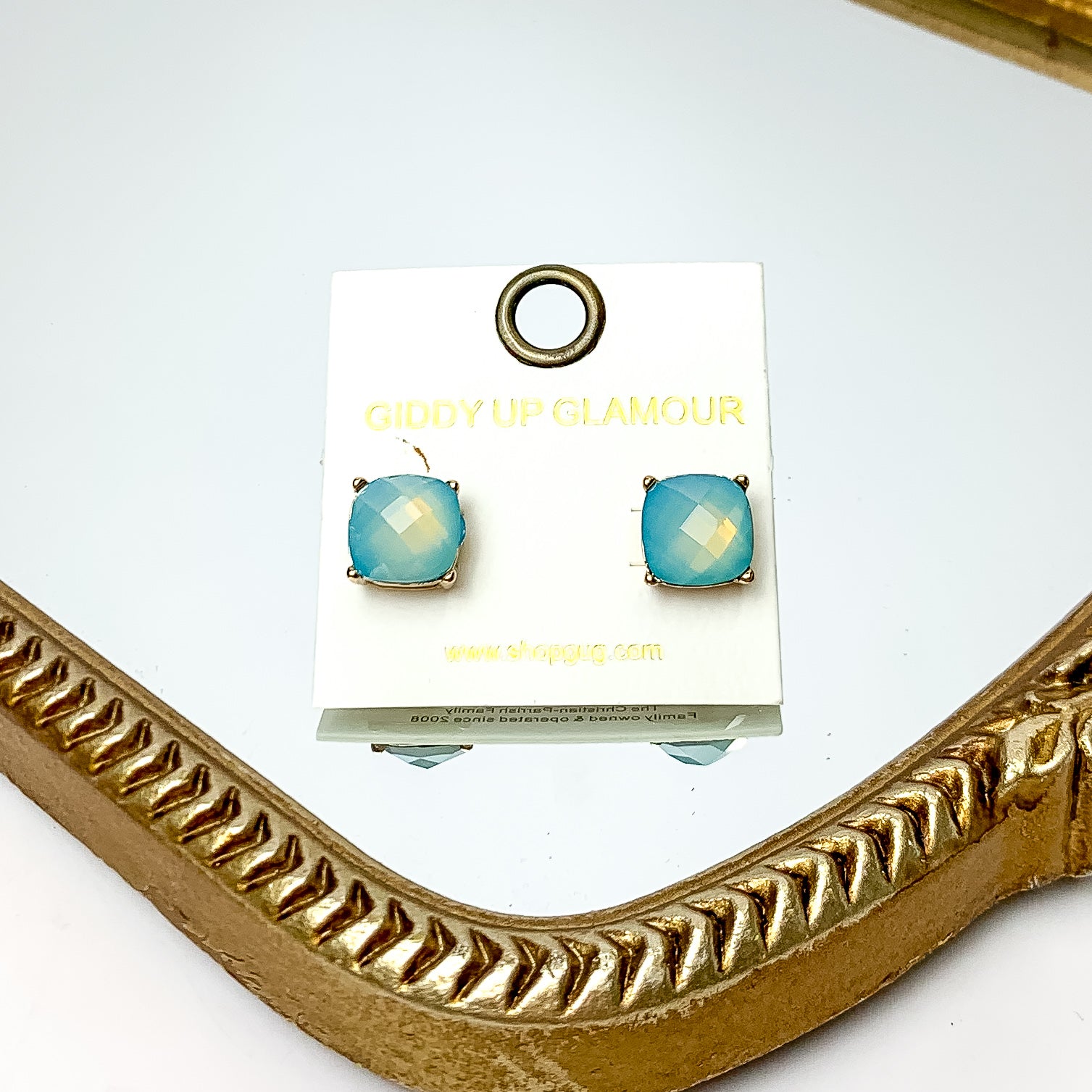 Large Crystal Stud Earrings in Light Blue. These earrings are pictured laying on a gold trimmed mirror.