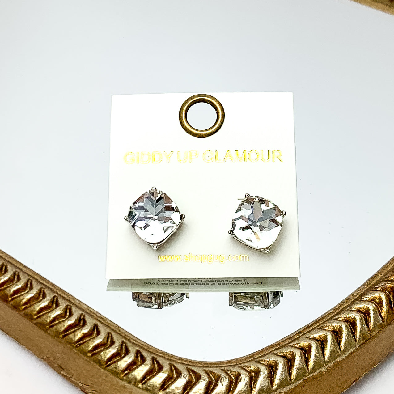 Large Clear Crystal Stud Earrings in Silver Tone. These earrings are pictured laying on a gold trimmed mirror.