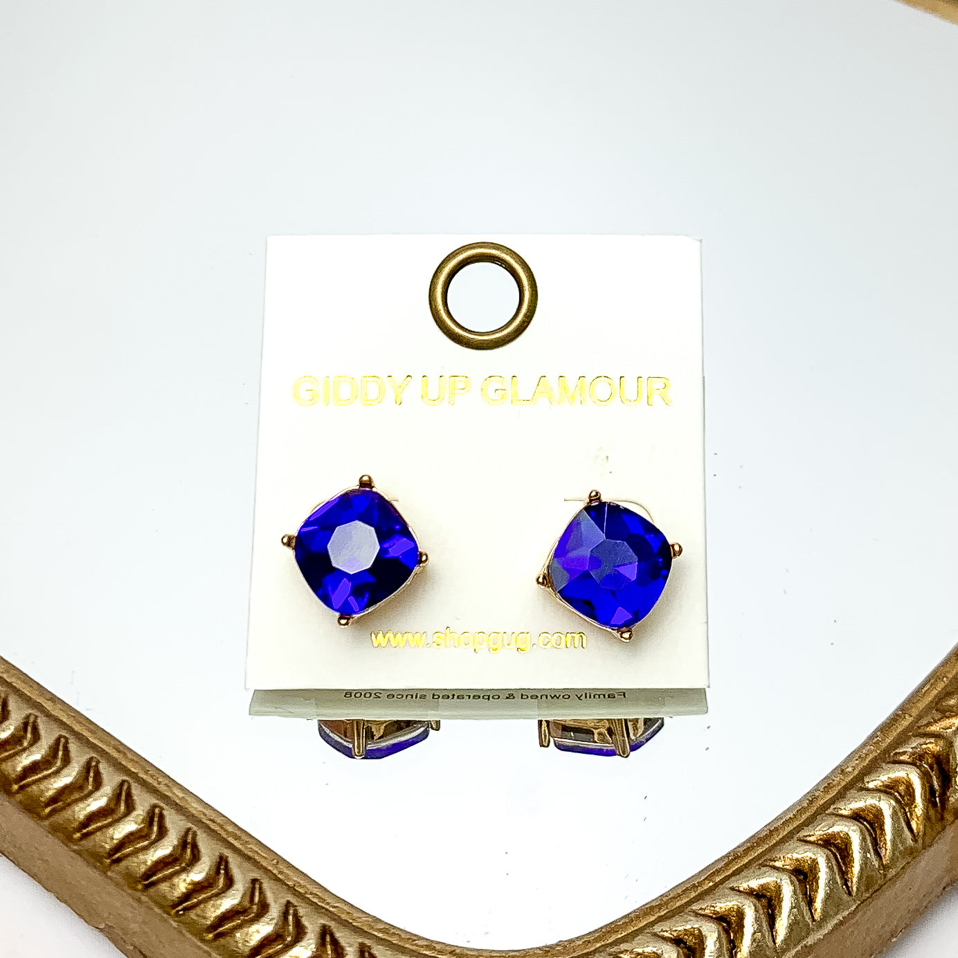 Large Crystal Stud Earrings in Royal Blue. These earrings are pictured laying on a gold trimmed mirror.