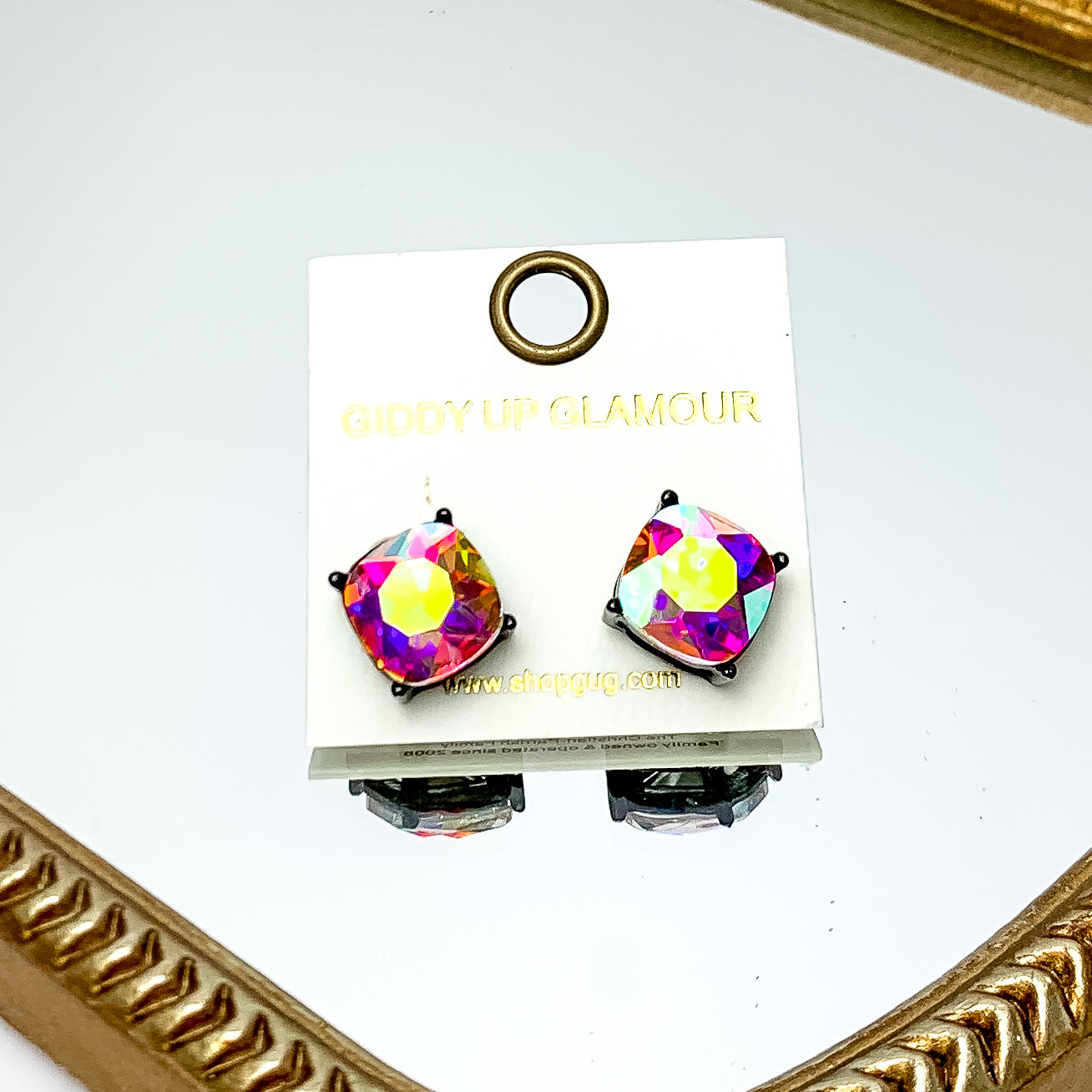 Large AB Crystal Stud Earrings in Silver Tone. These earrings are pictured laying on a gold trimmed mirror.