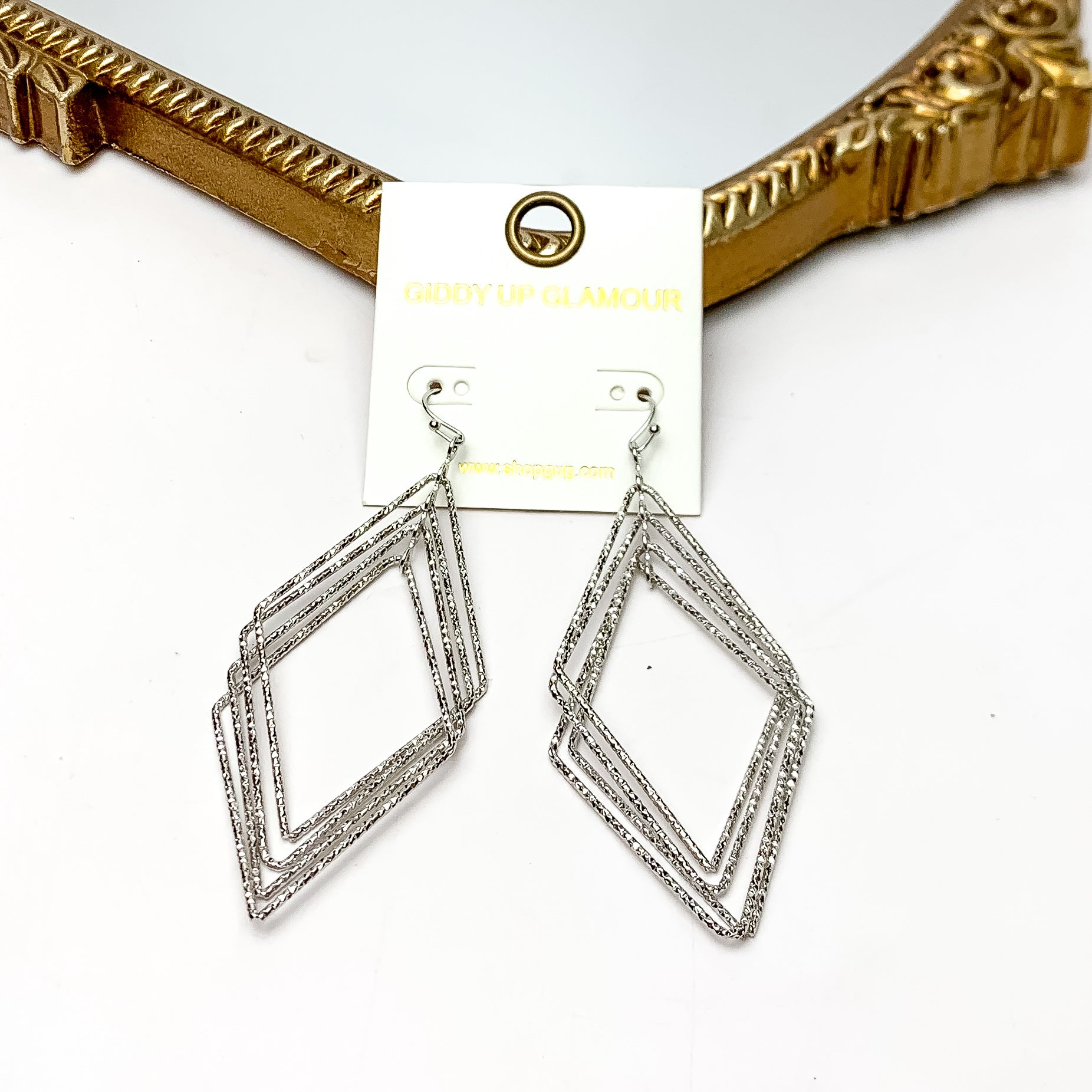 Multiple layered Diamond Shaped Earrings in Silver Tone. These earrings are pictured on a white background with a gold frame around.