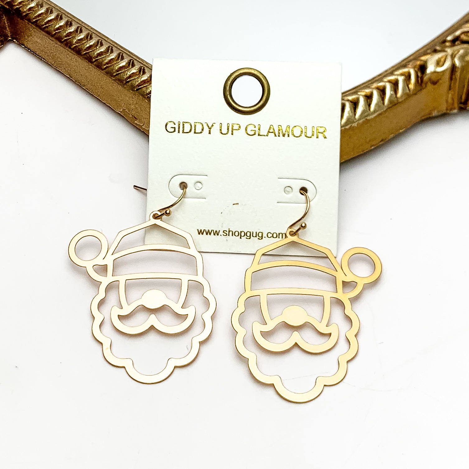 Santa Outline Earrings in Gold Tone. These earrings are pictured on a white background with a gold frame around.