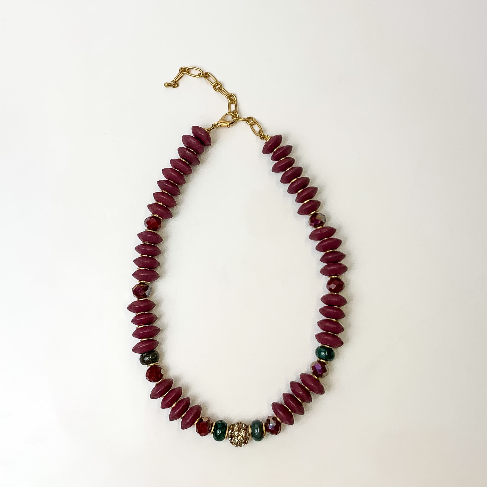 This beaded necklace in Mulberry purple is placed down on a white background.