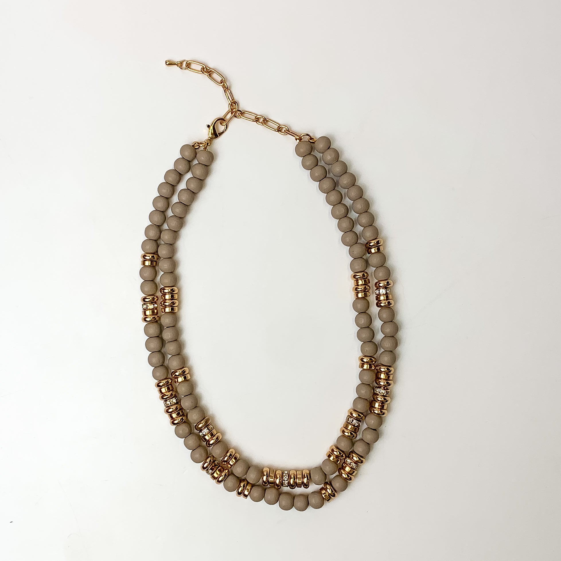This layered necklace in gray has gold spacers. It is taken with a white background.